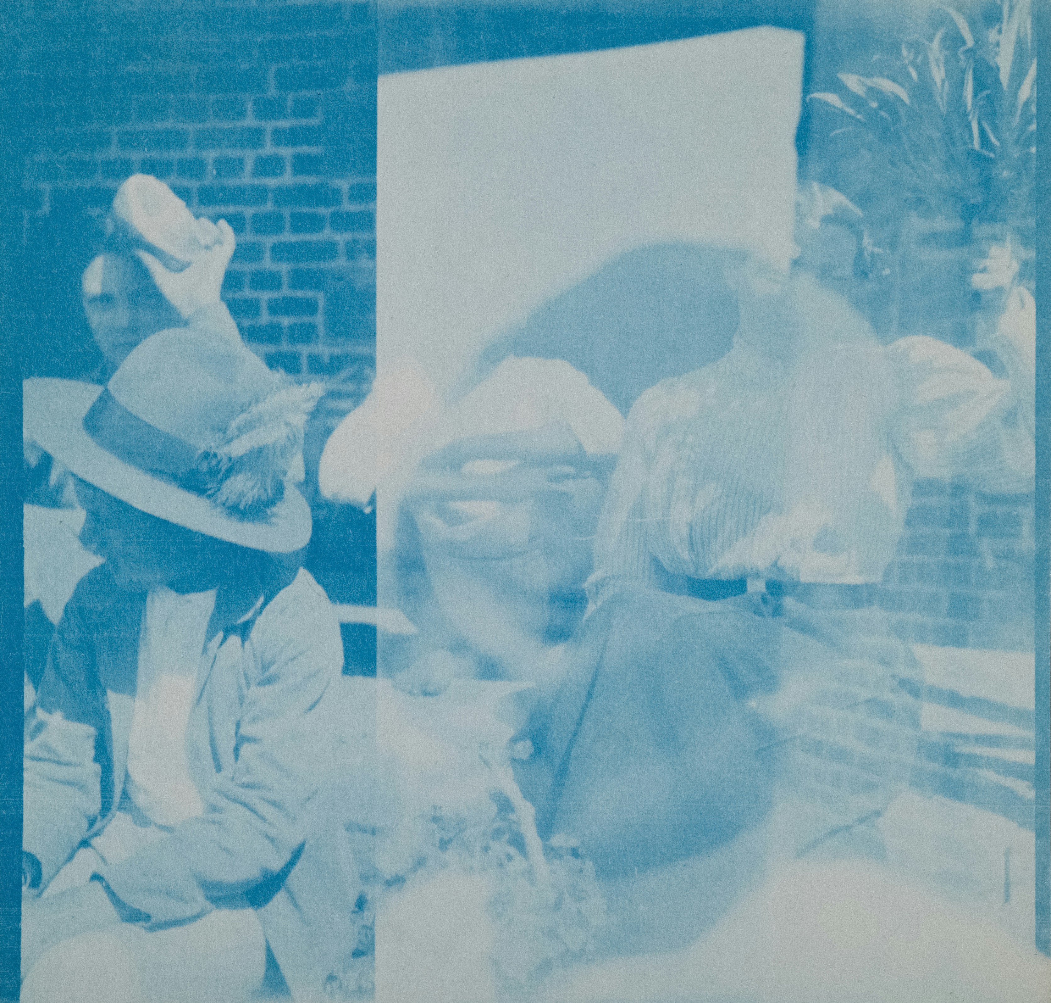 People gathered outdoors with a brick wall background