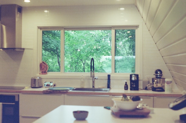 A kitchen with a sink, stove, dishwasher and a window