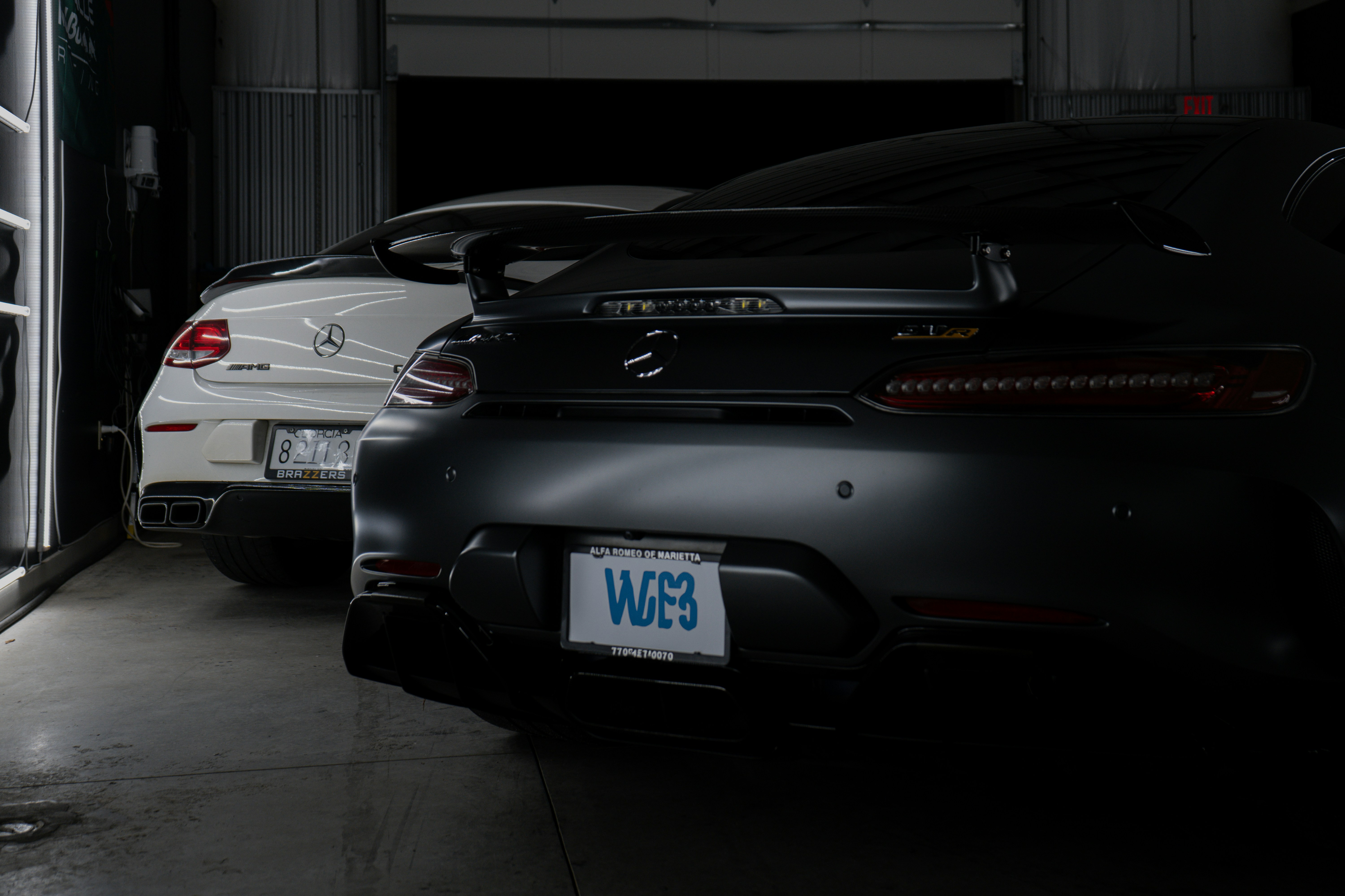A couple of cars are parked in a garage