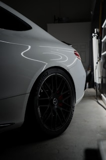 A white car parked in a garage next to a window