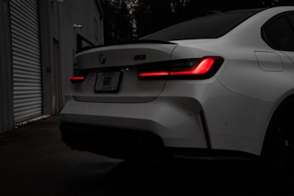 A white car parked in a garage next to a building