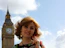 A woman standing in front of a clock tower