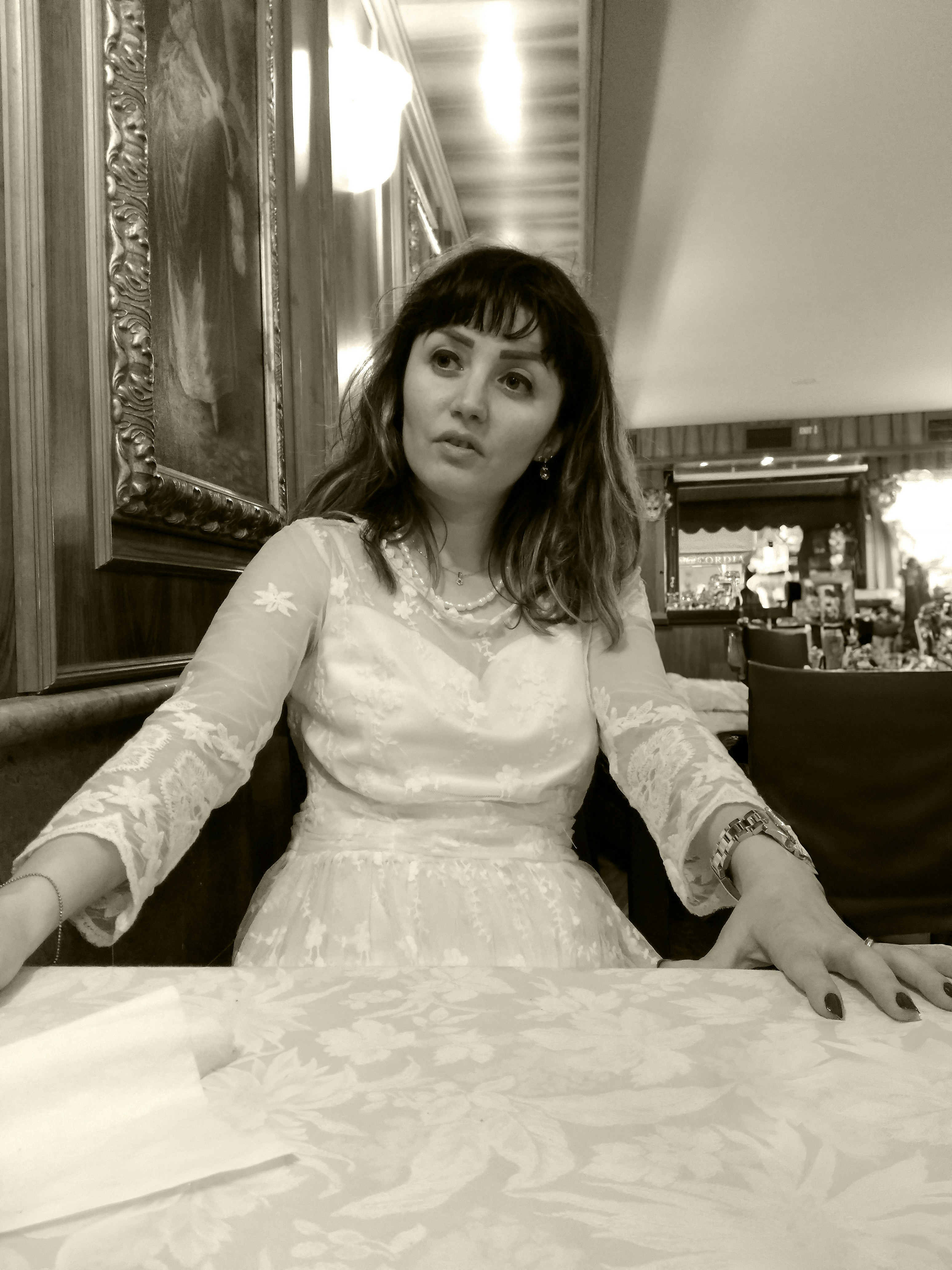 Eine Frau in einem weißen Kleid sitzt auf einer Couch