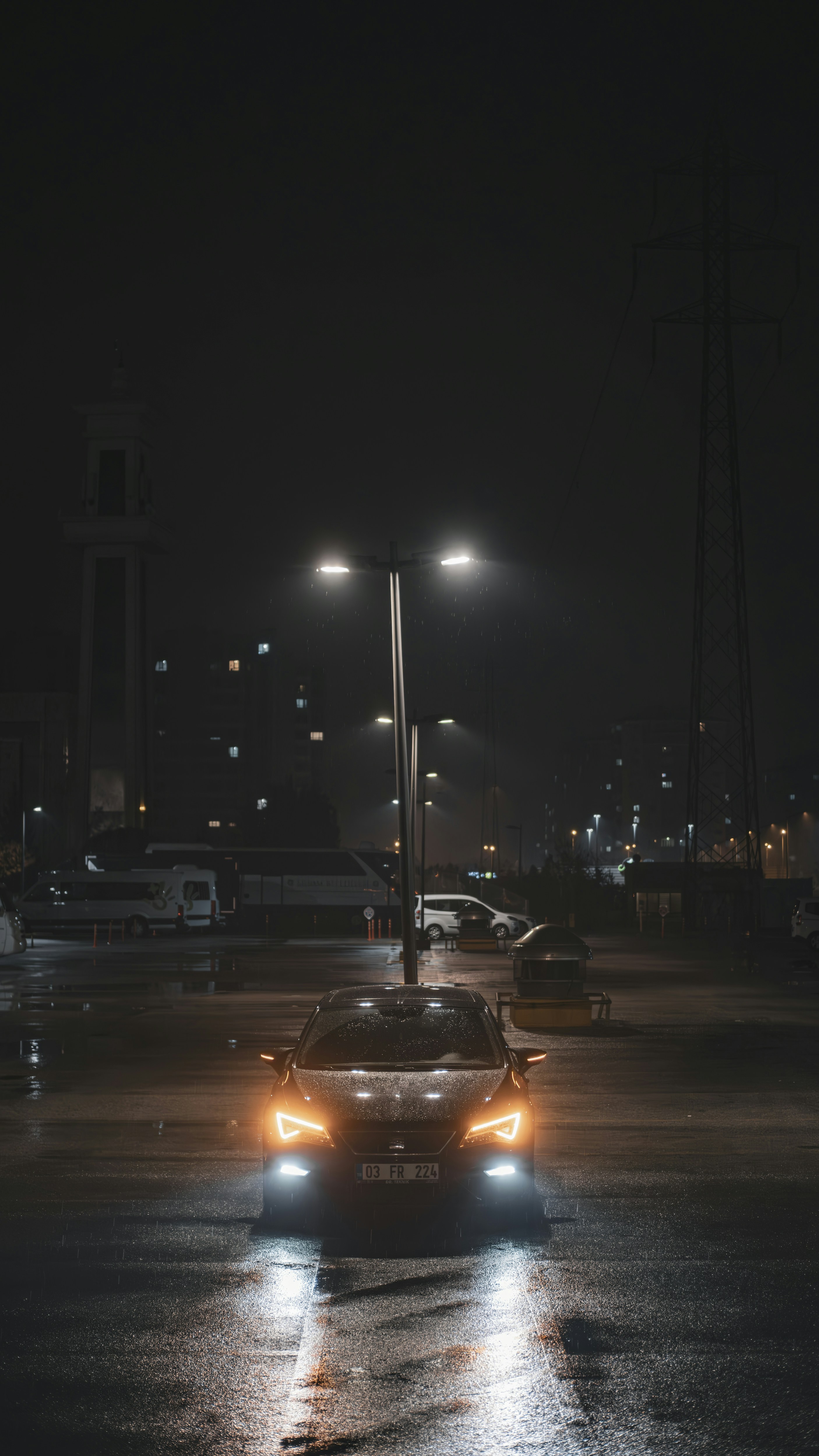 A car driving down a wet street at night