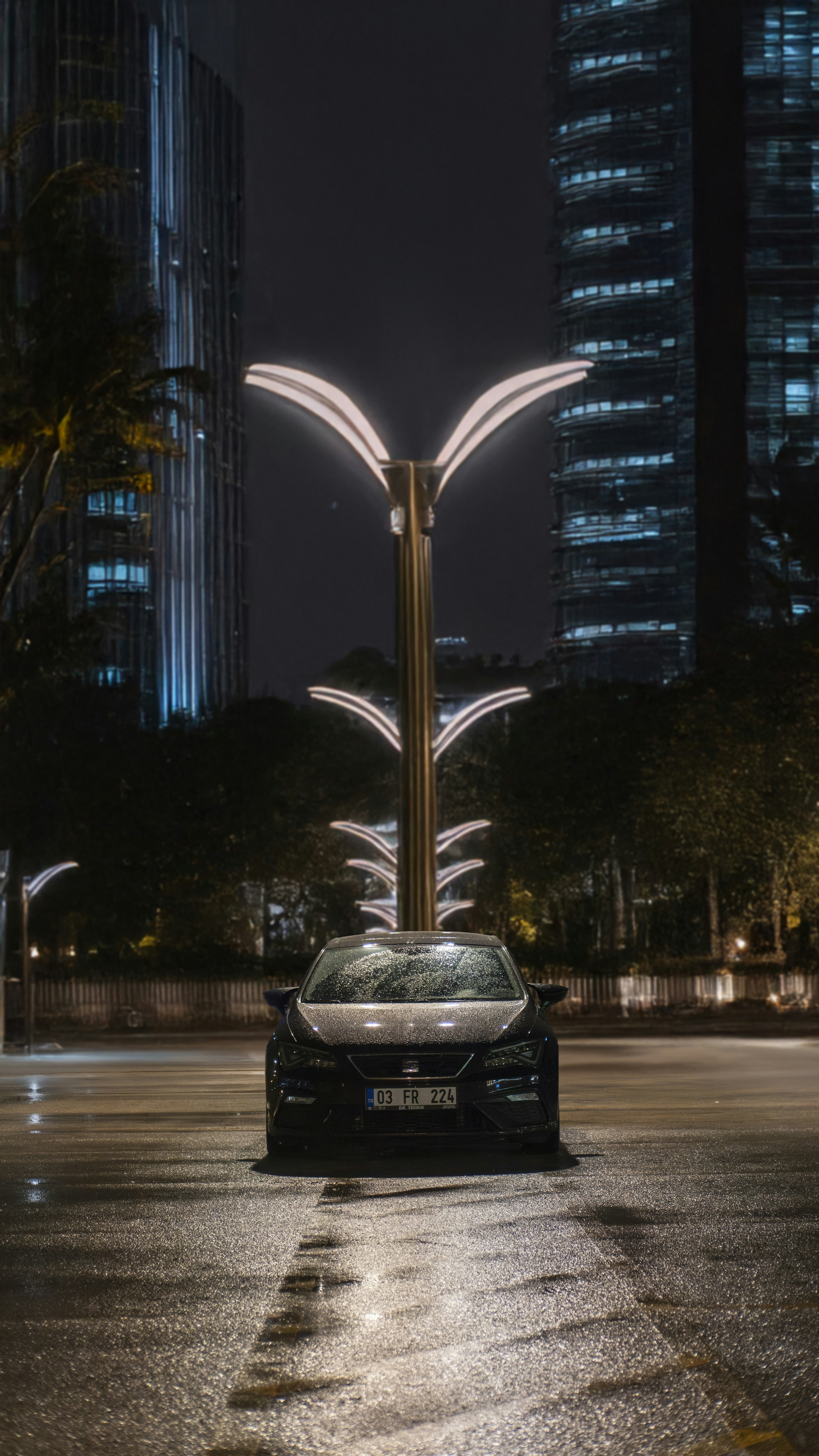 A car parked in a parking lot at night