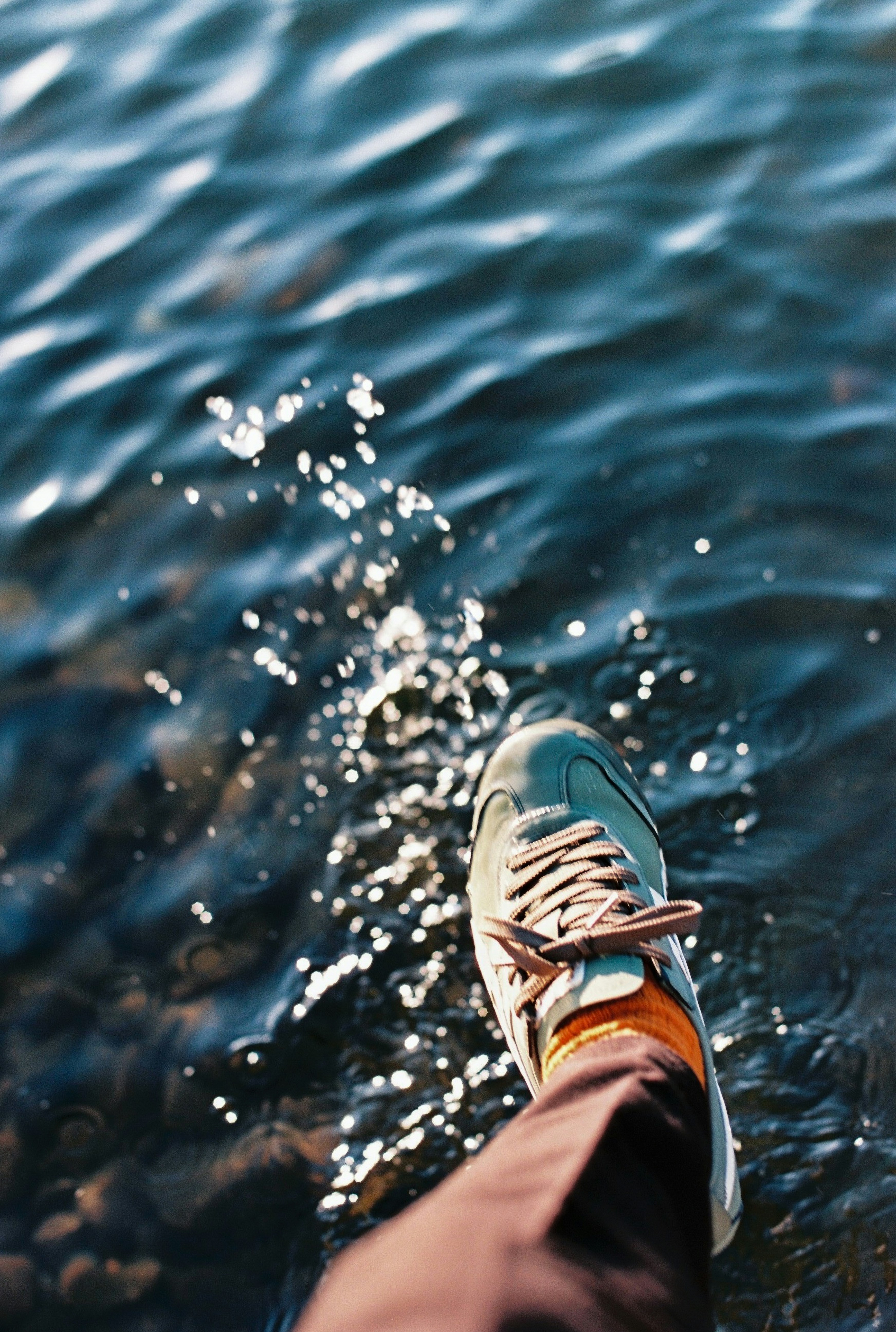 A person standing in the water with their feet in the water