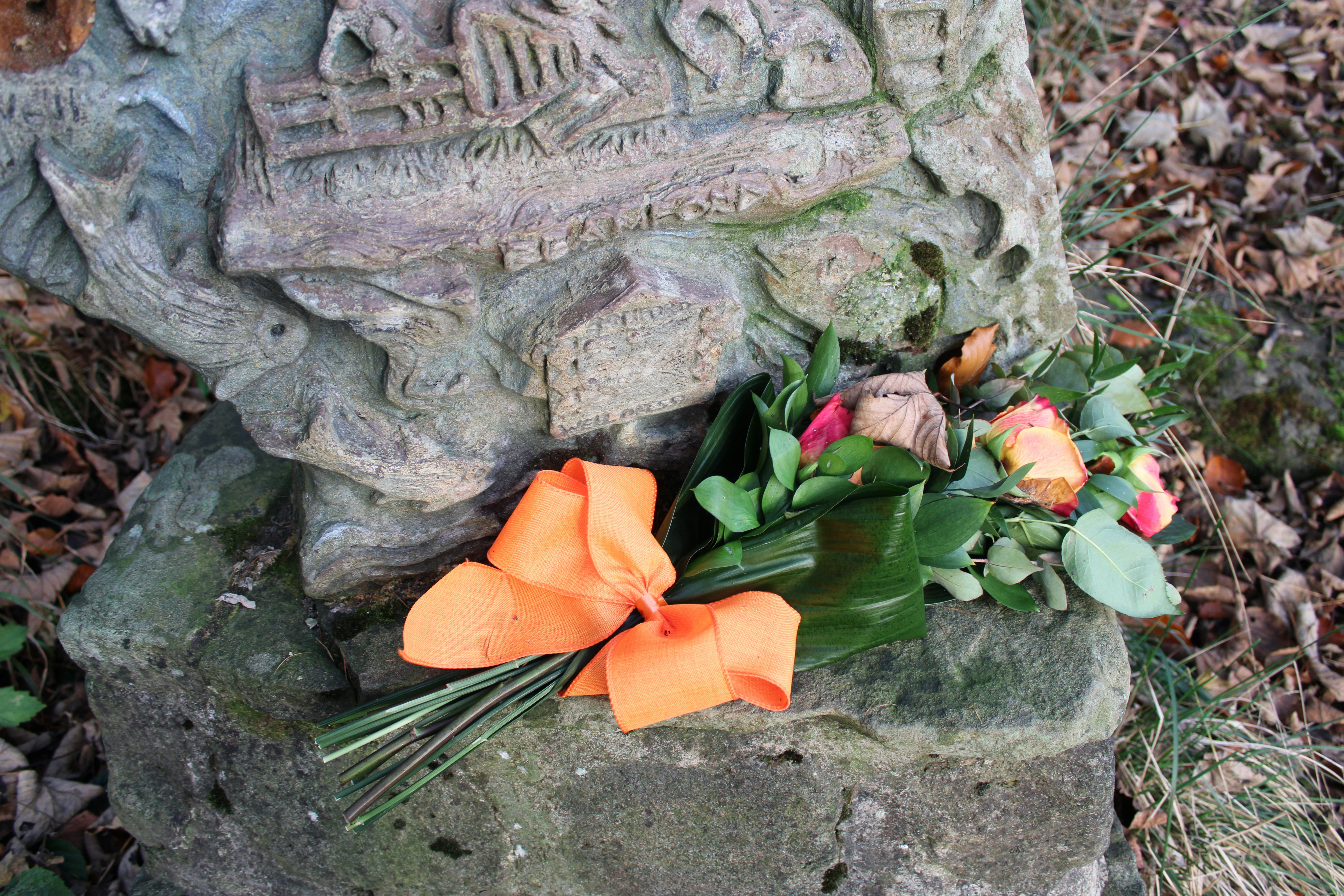 A grave with flowers and a skeleton on it