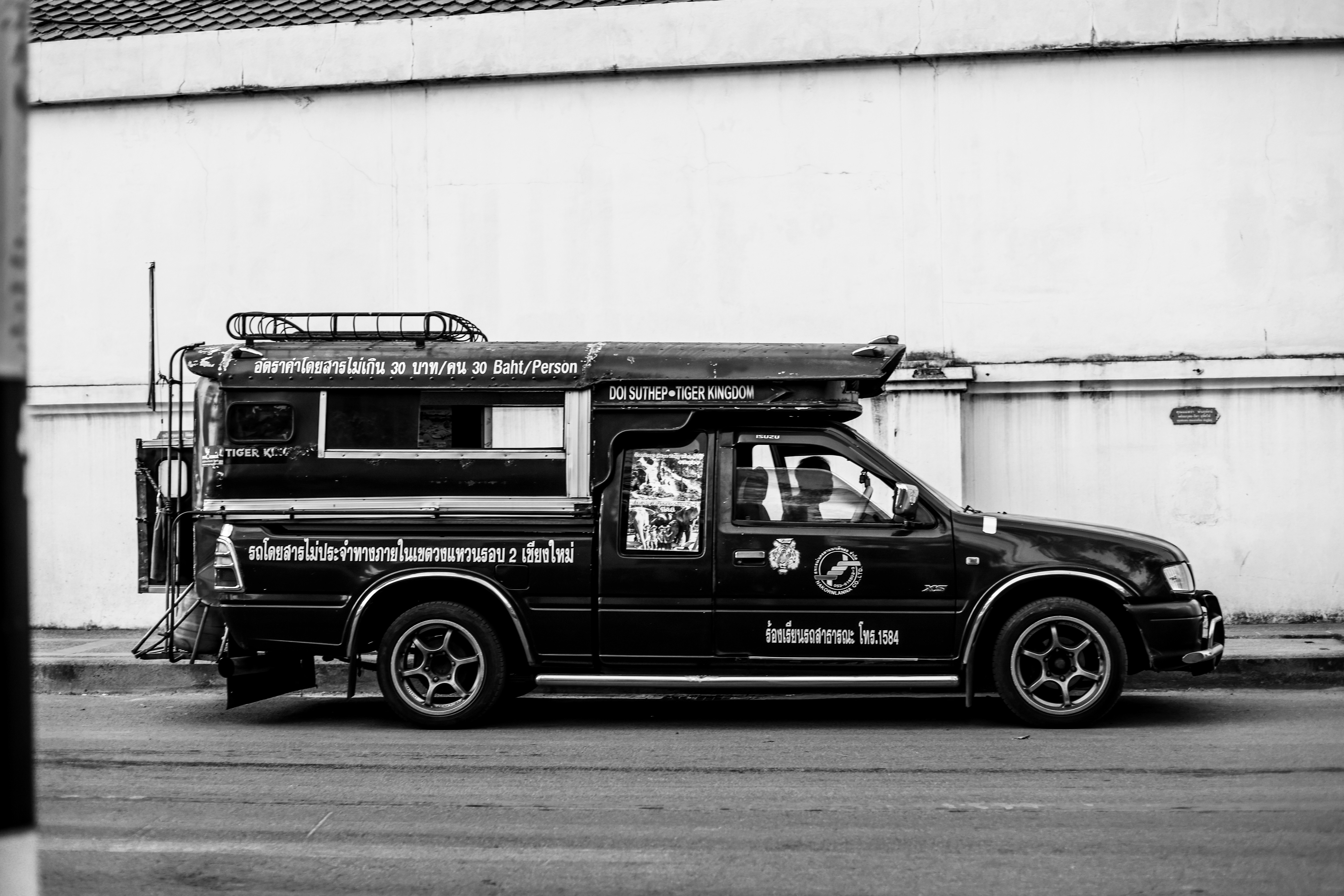 A black and white photo of a truck parked in front of a building