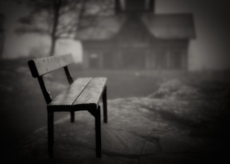 A wooden bench sitting in front of a house