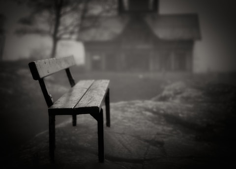 A wooden bench sitting in front of a house