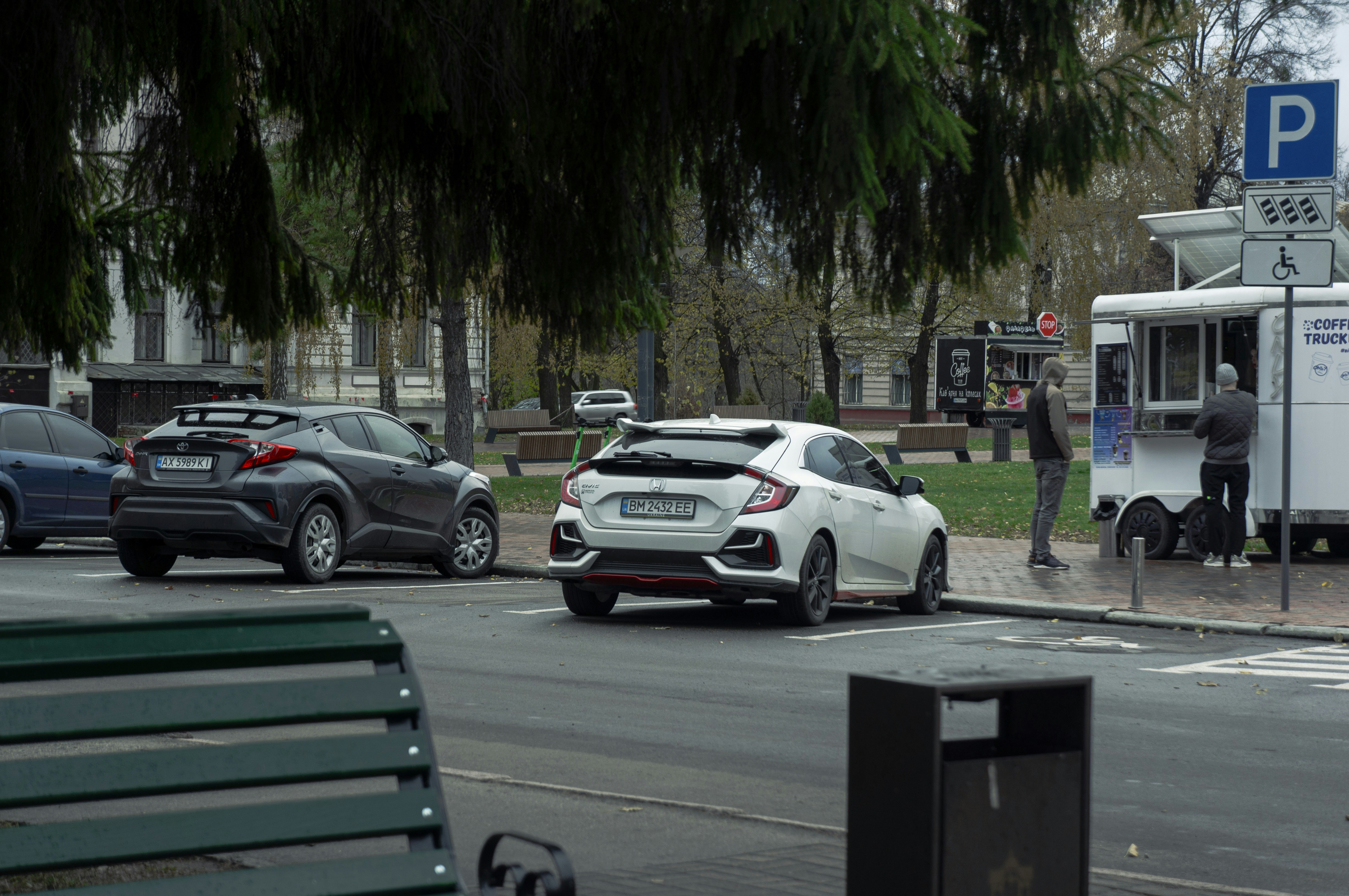 Compact electric car parked on a city street curbside charging
