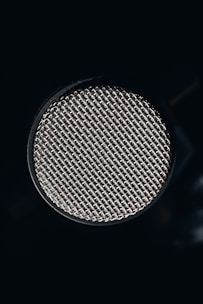 A close up of a microphone on a black background