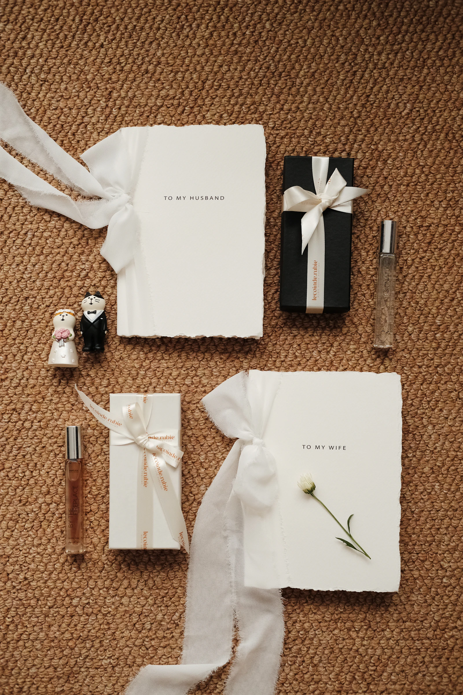 Flat lay de cadeaux de mariage sobres avec rubans blancs et carnets de voeux