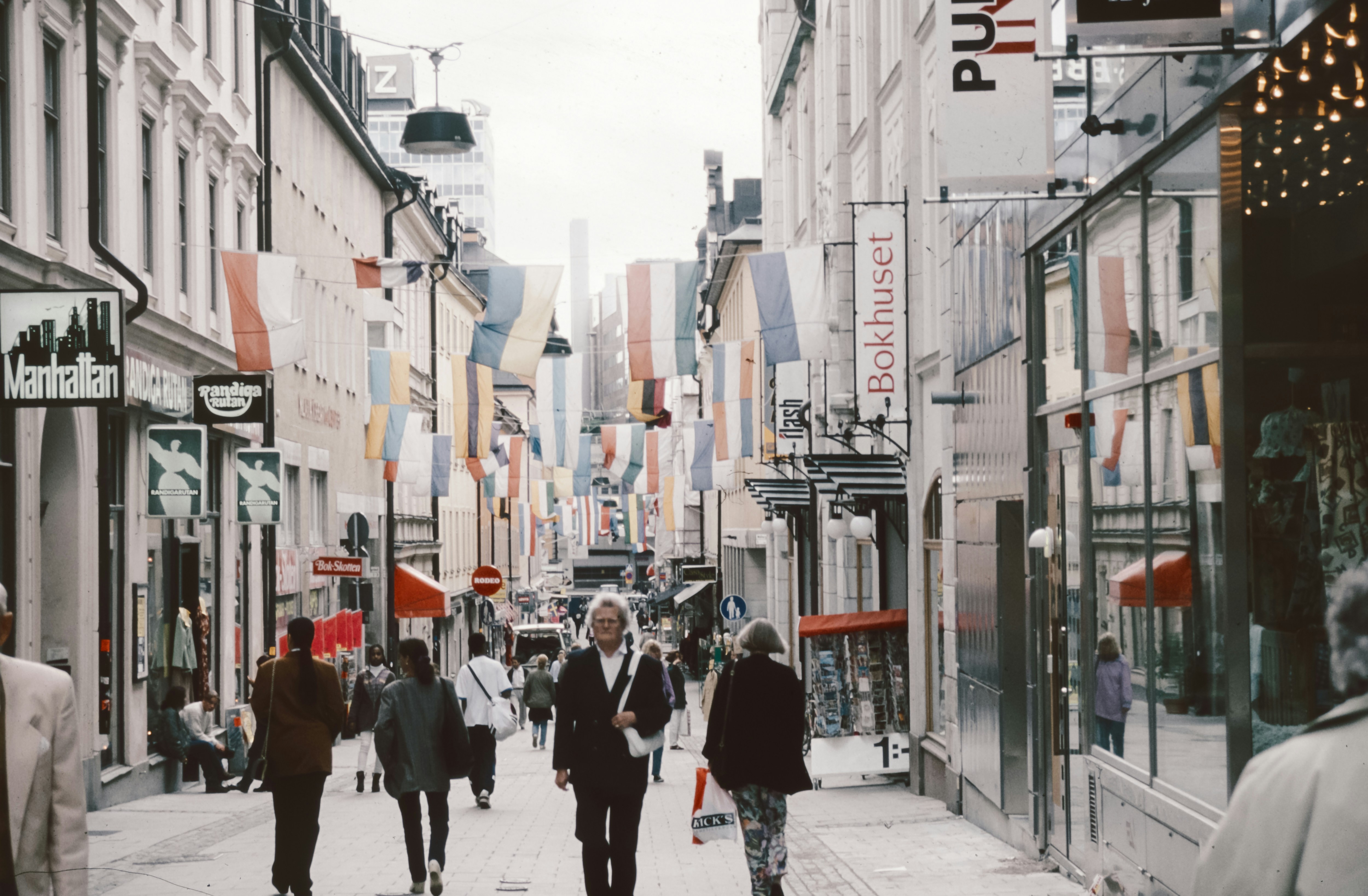 Eine Gruppe von Menschen geht eine Straße neben hohen Gebäuden entlang