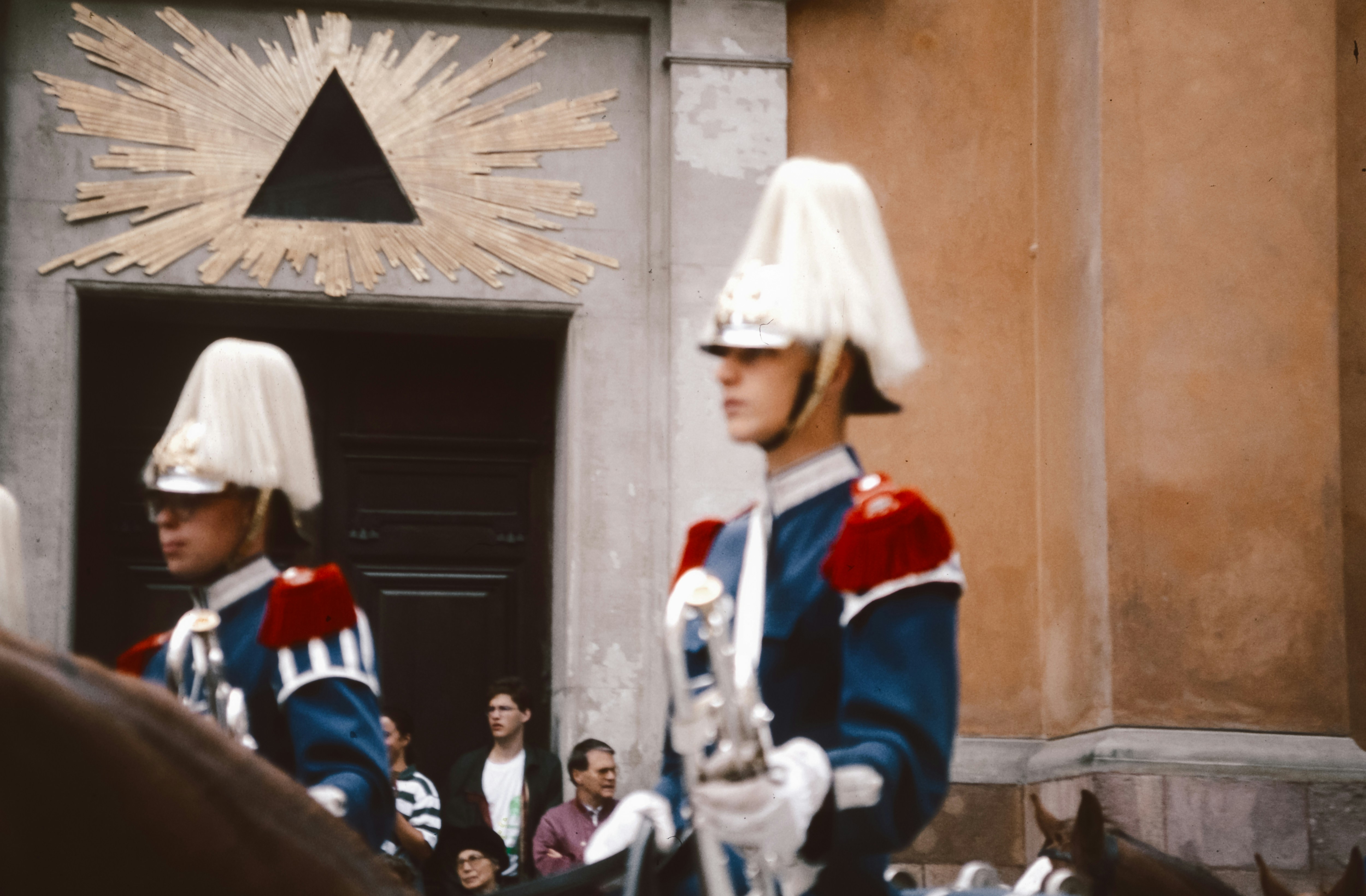 A group of men in uniform riding horses down a street
