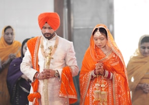 A man and a woman dressed in orange and white