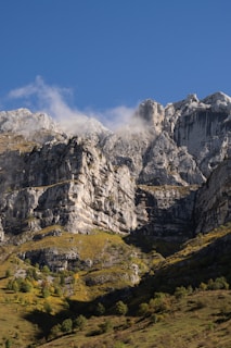 A mountain range with a few clouds in the sky