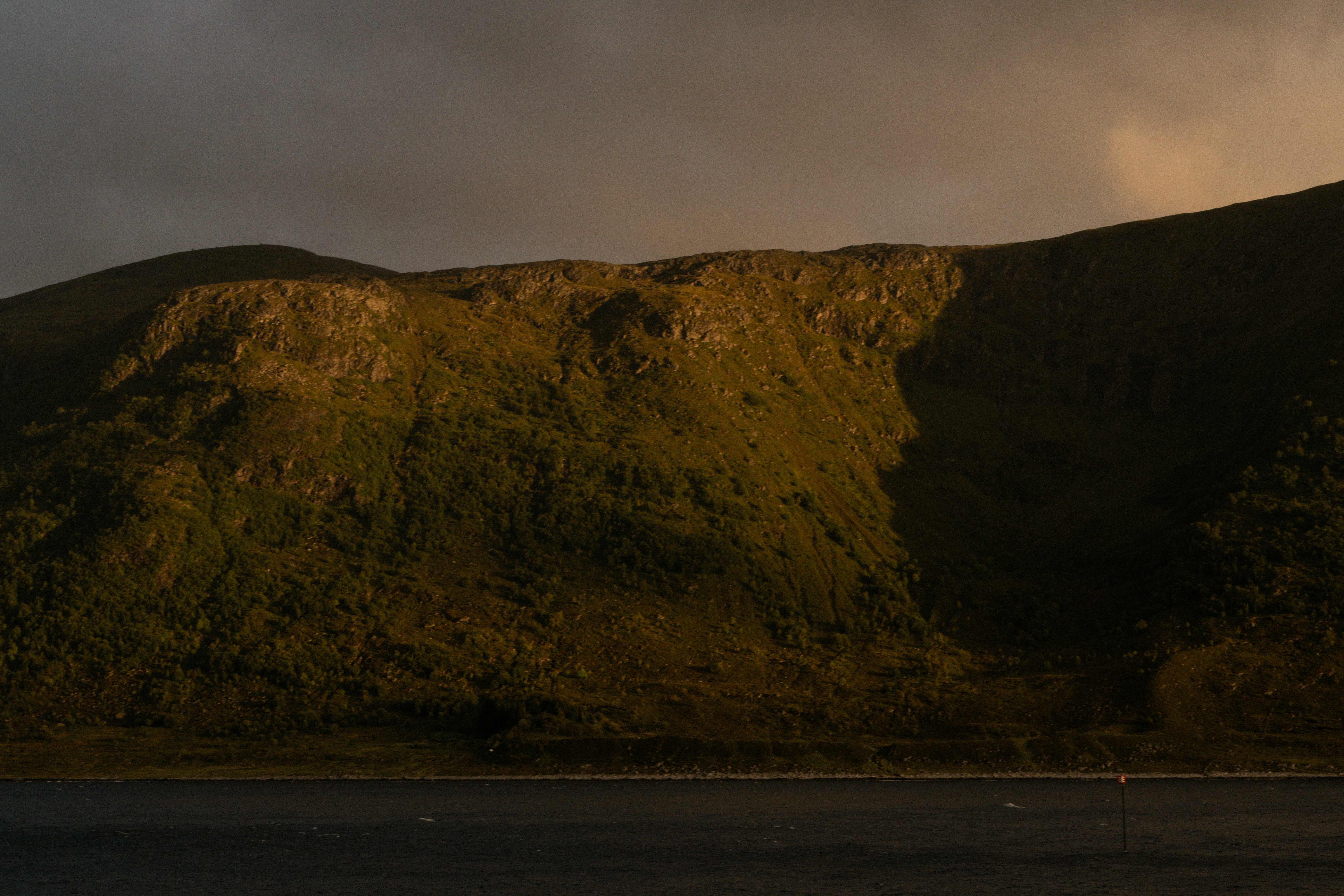 A mountain with a dark sky in the background