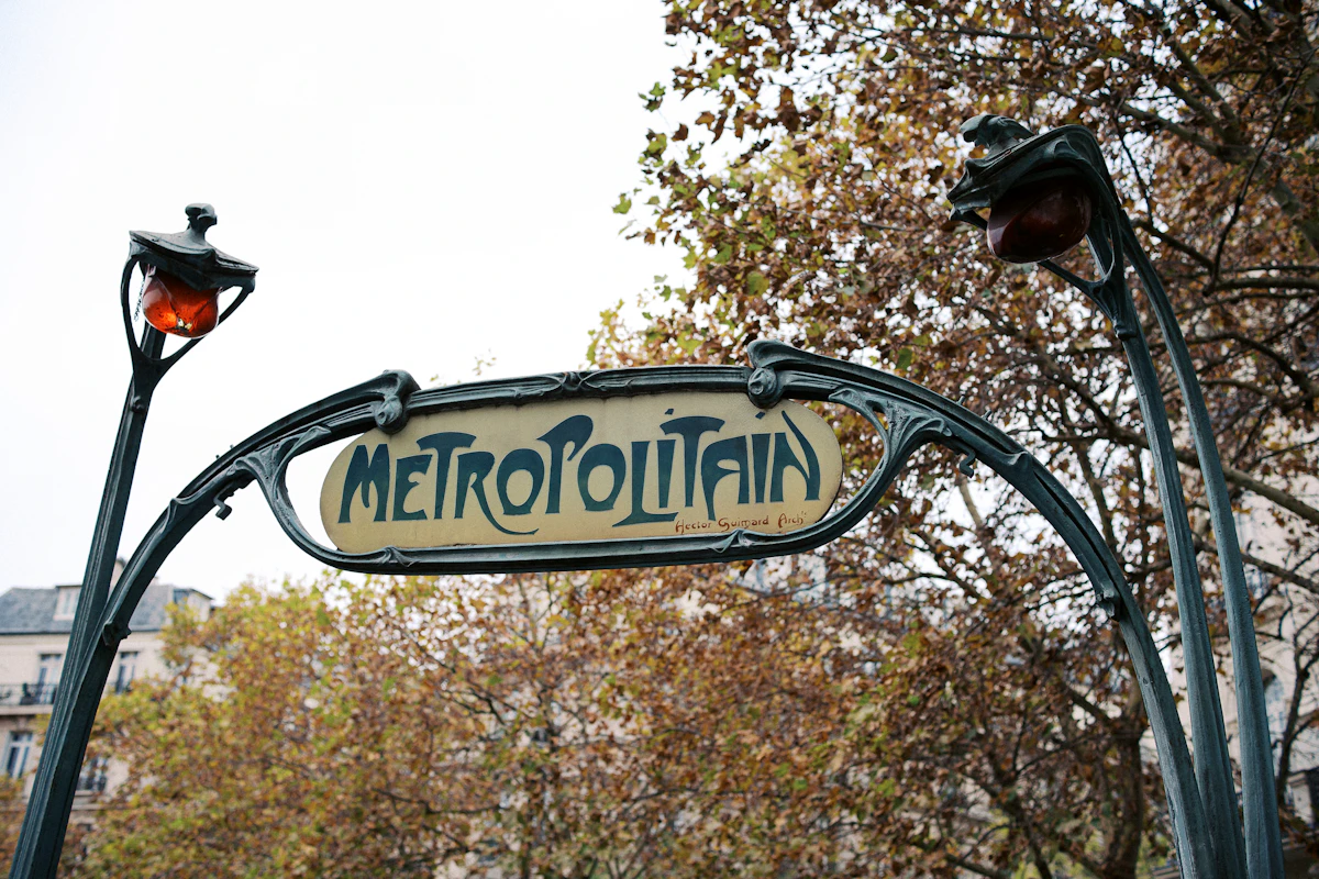 Enseigne verte et blanche d'une entrée de station de métro parisien, signalétique Métropolitain.