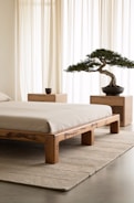 A bedroom with a bed and a bonsai tree