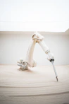 A robotic arm holding a screwdriver on top of a table