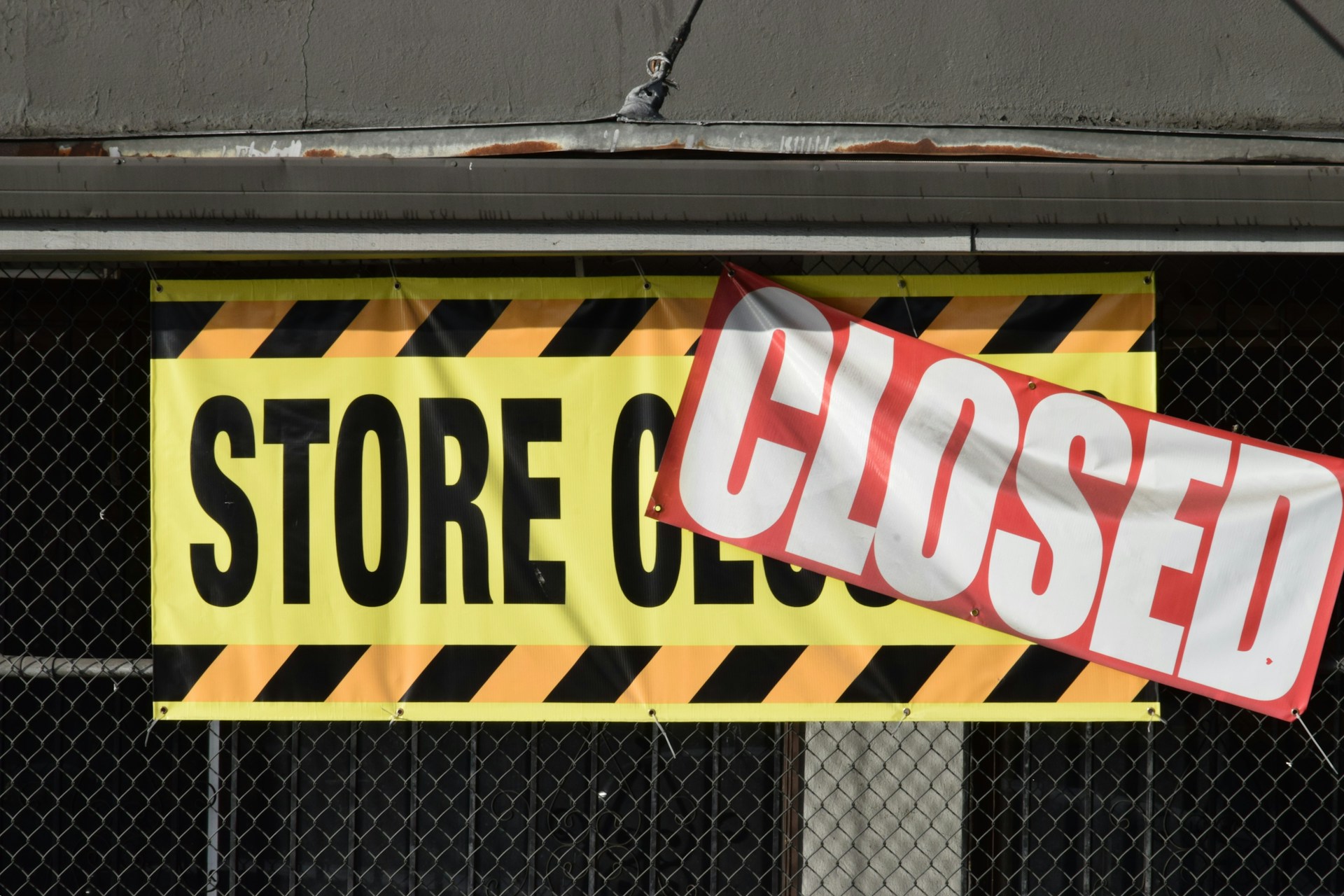 A store closed sign hanging from the side of a building