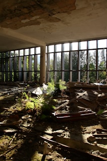 An abandoned building with lots of windows and debris