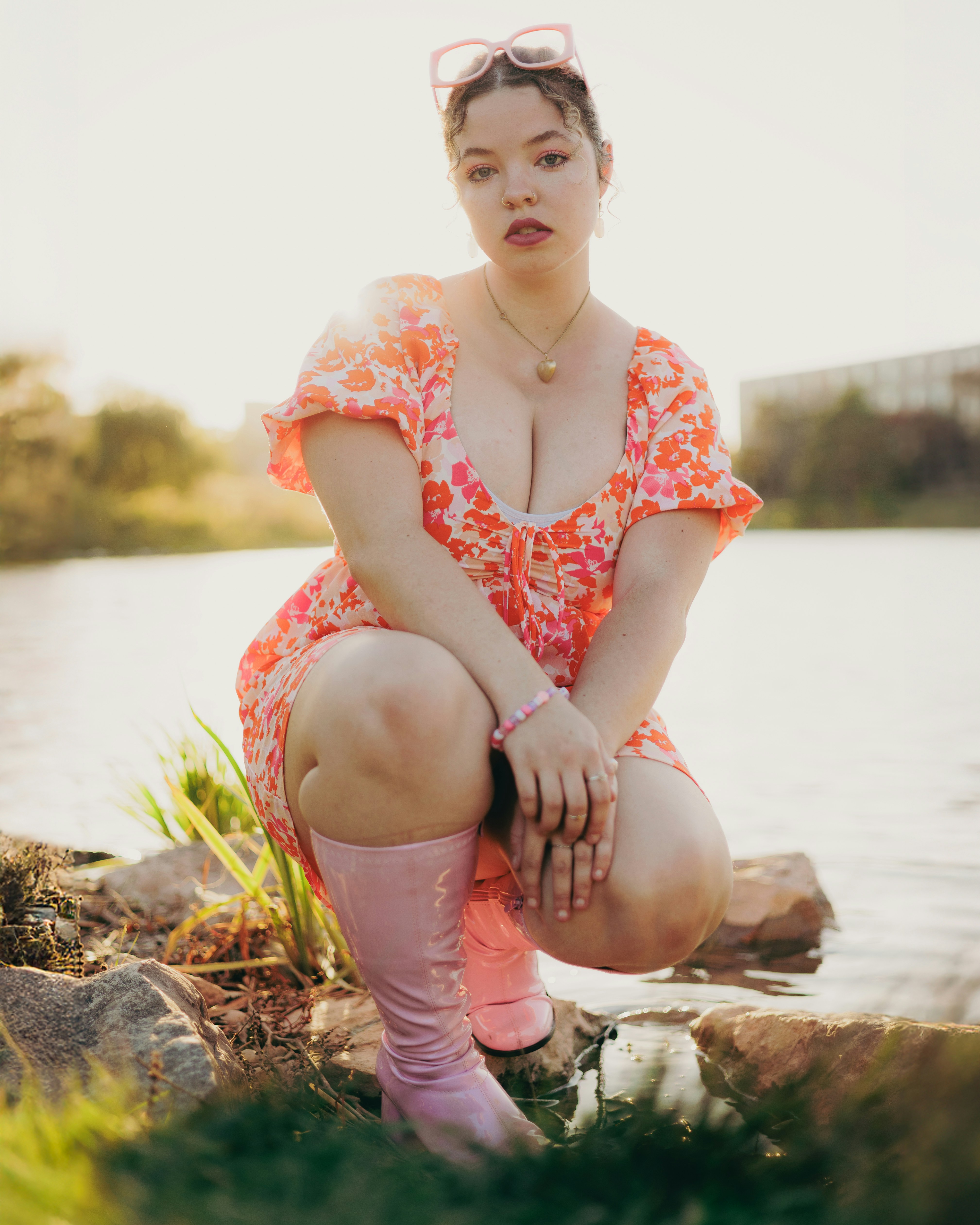 A woman sitting on a rock next to a body of water