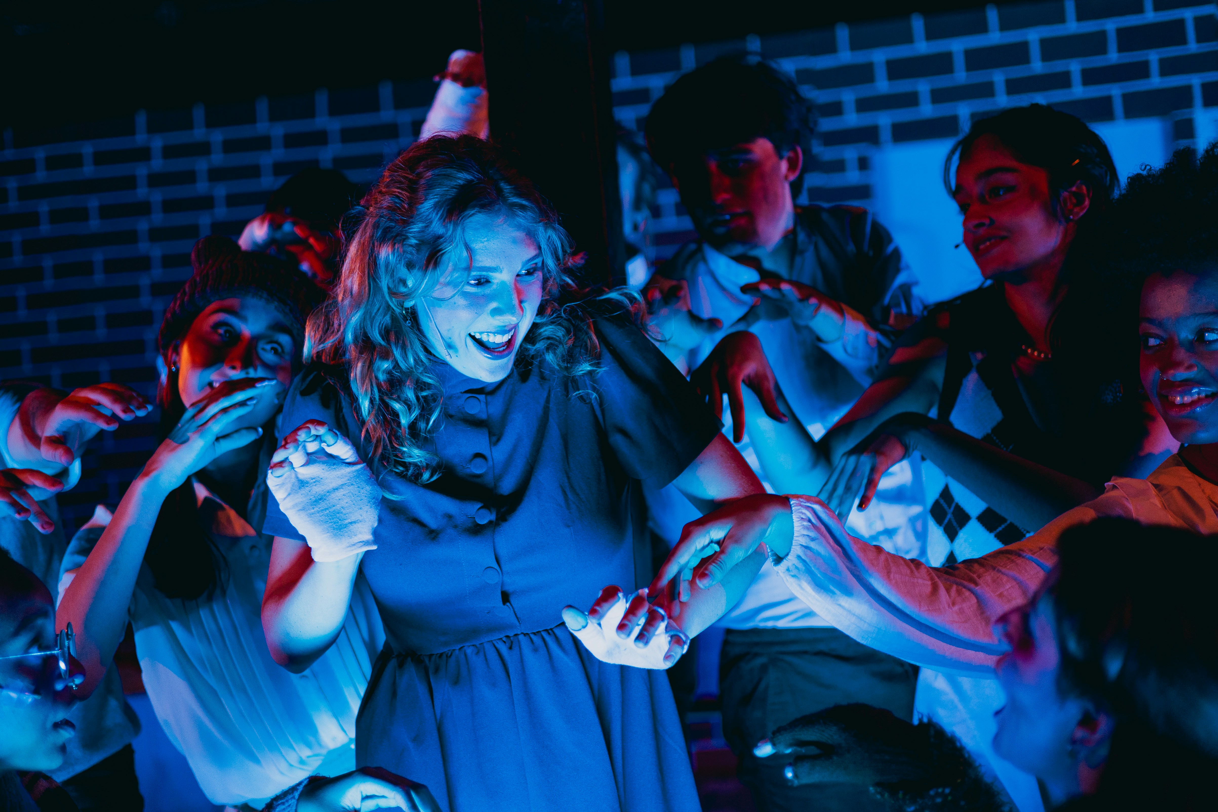A group of people standing around a woman in a blue dress