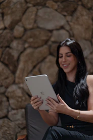 A woman sitting on a chair using a tablet