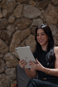 A woman sitting on a chair using a tablet