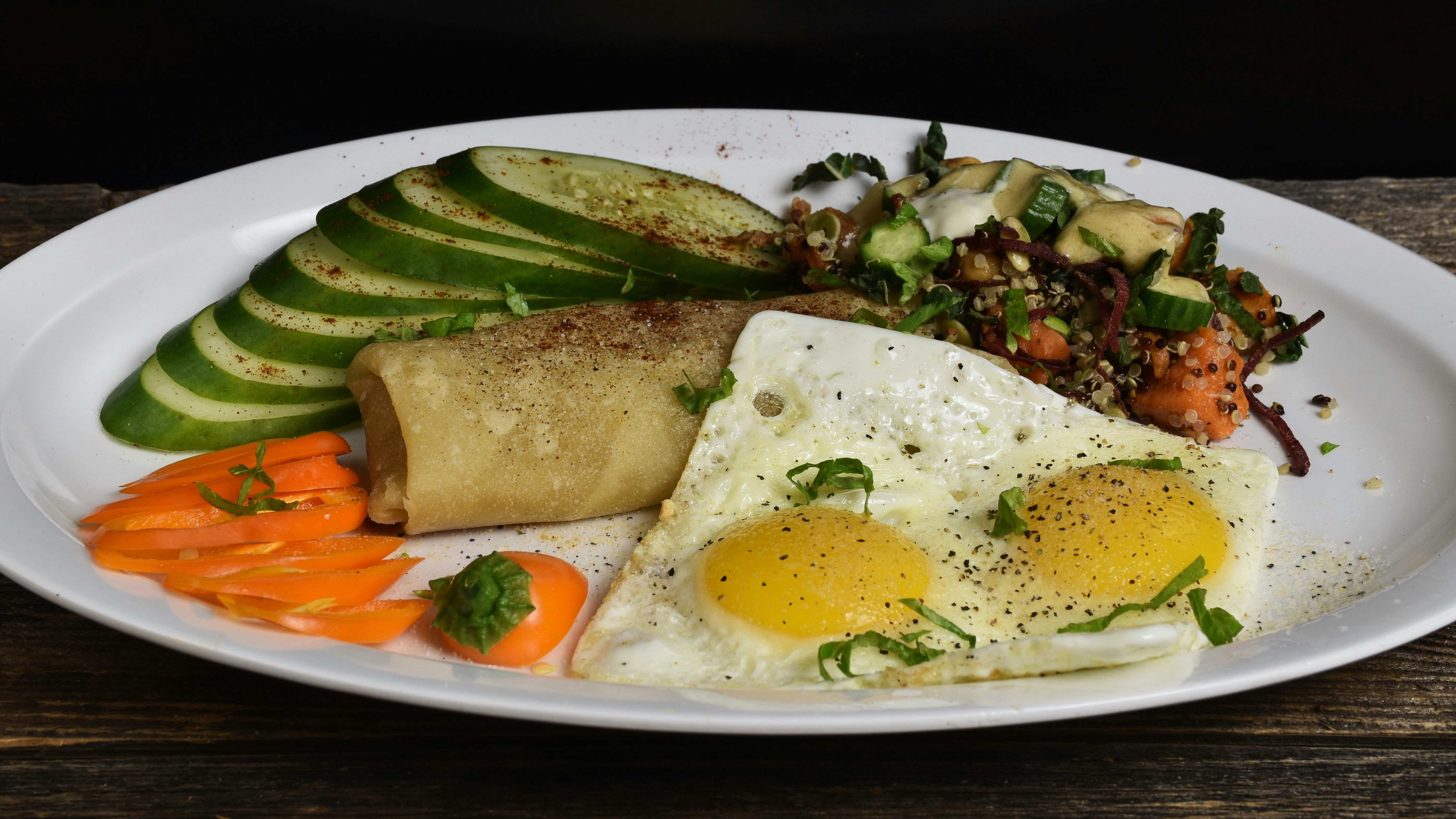 Fried eggs with avocado, crepe and salad