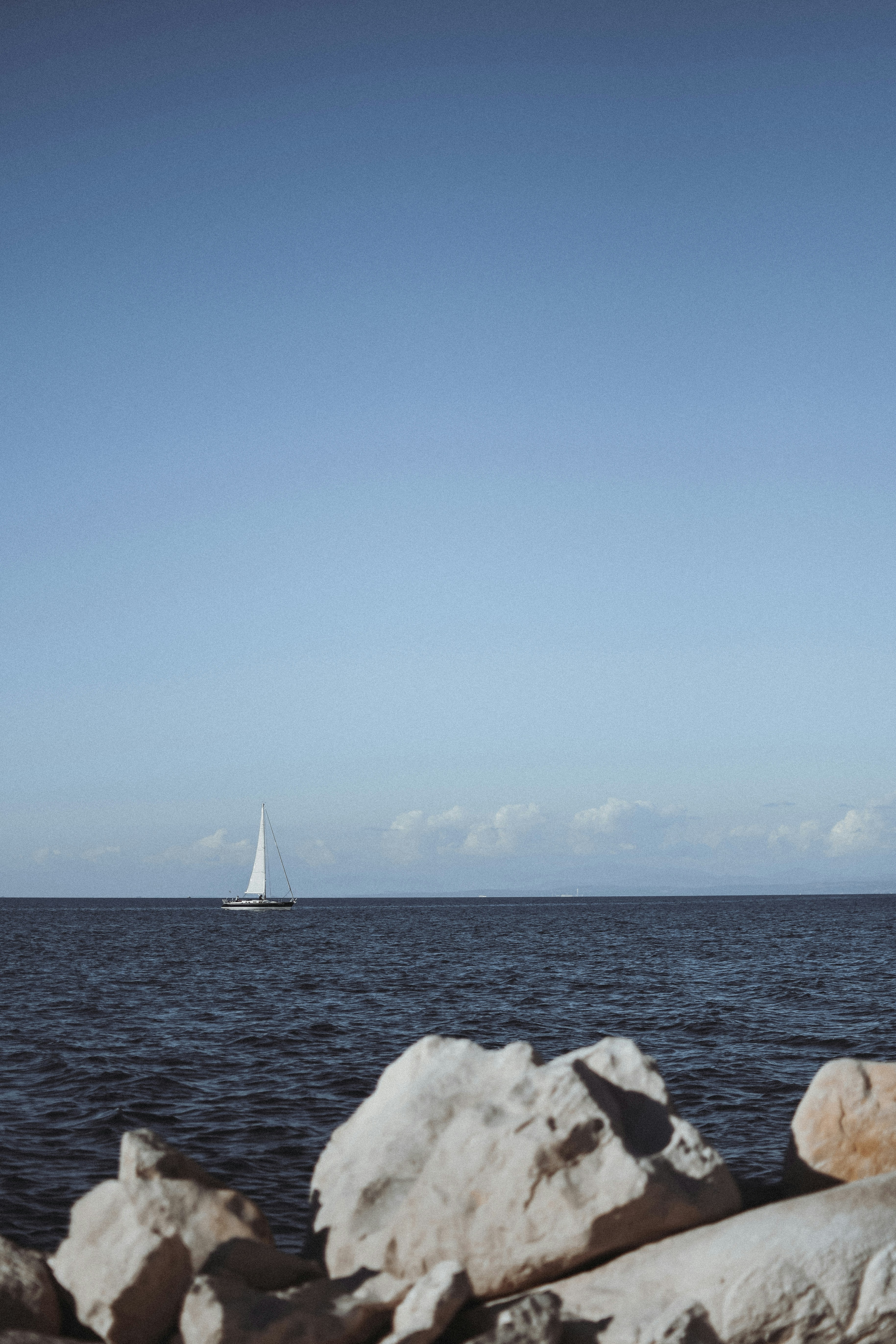 A sailboat is in the distance on the water