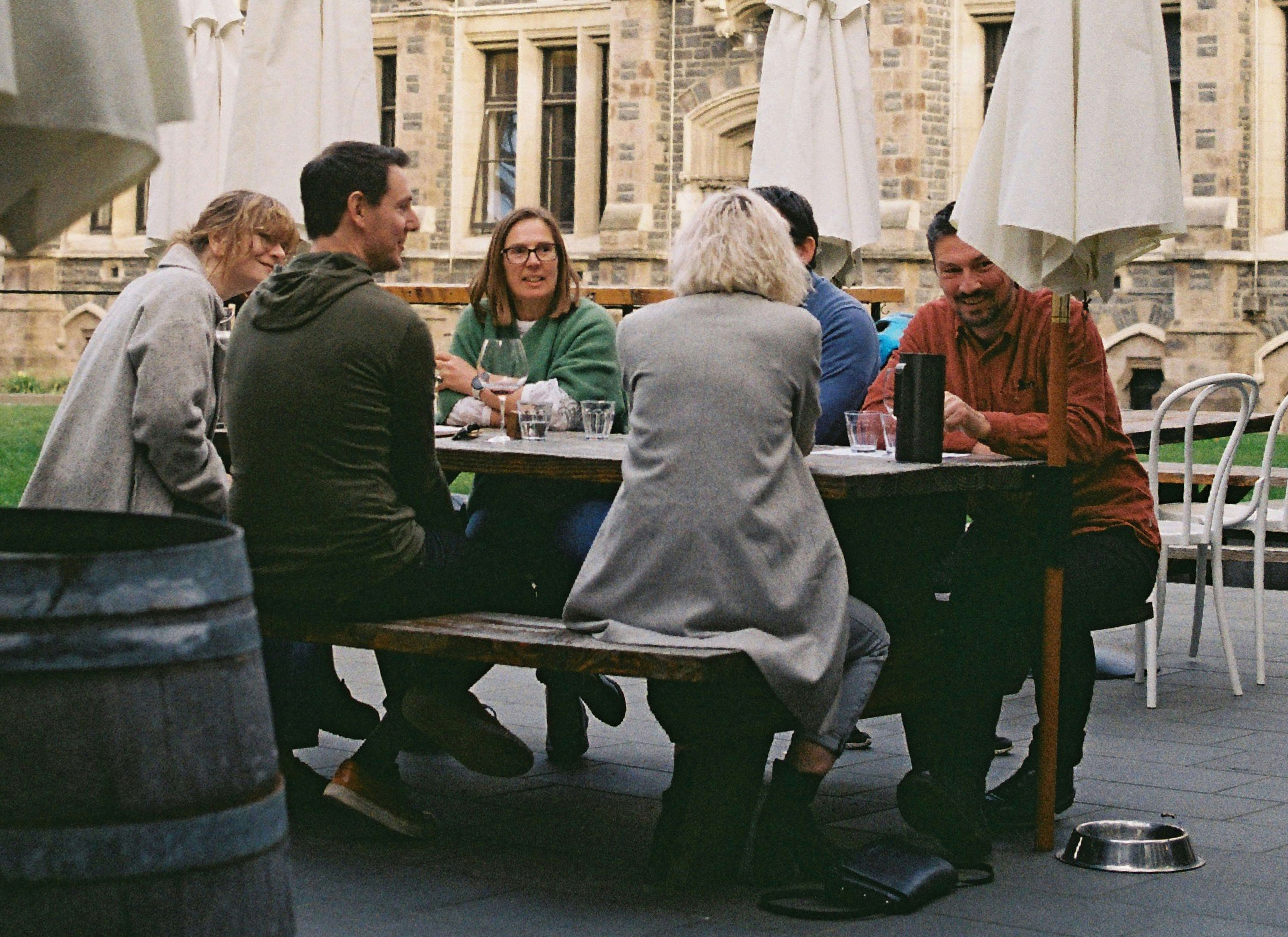 A group of people sitting at a table outside