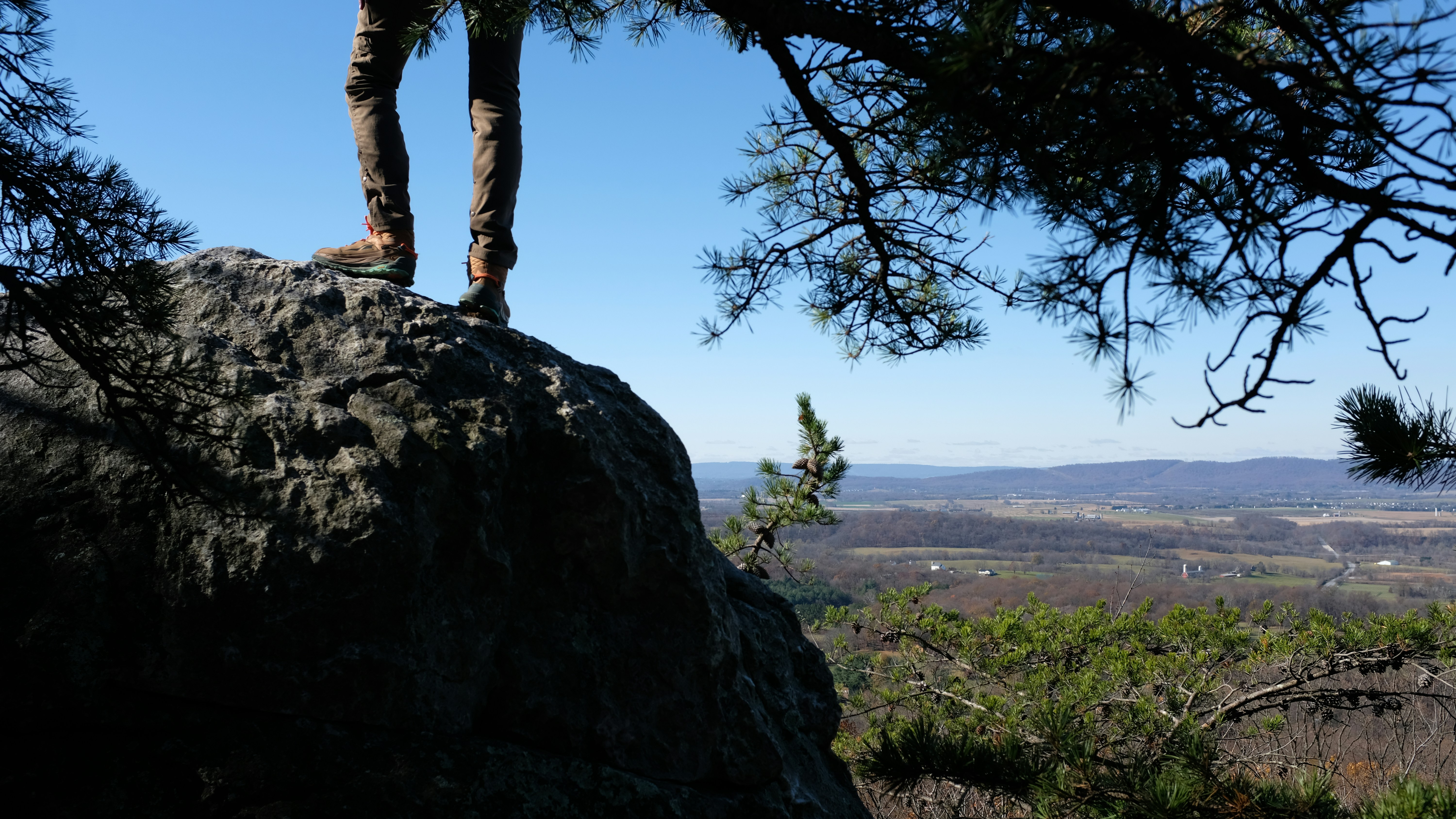 A person standing on top of a large rock