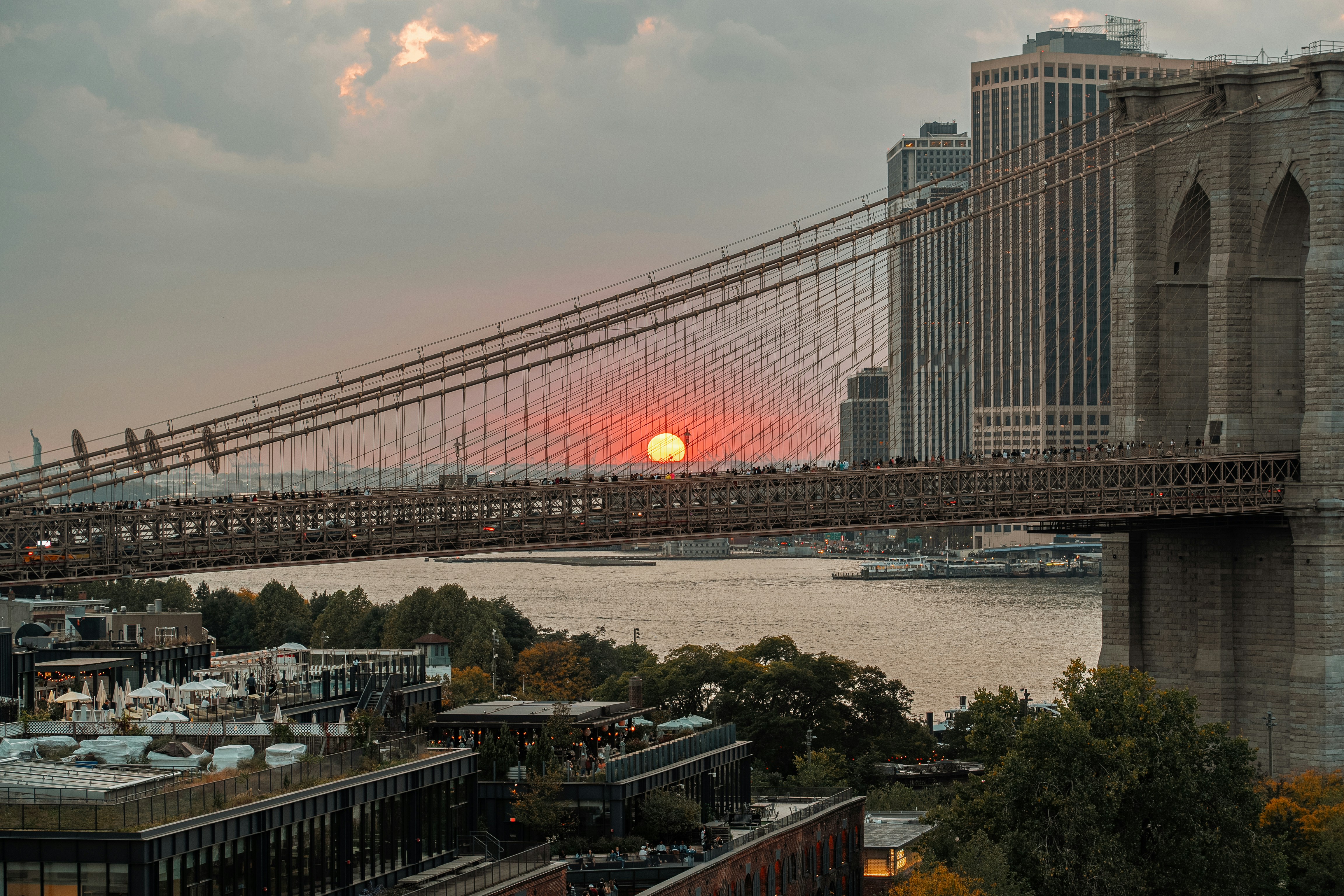 The sun is setting over the brooklyn bridge