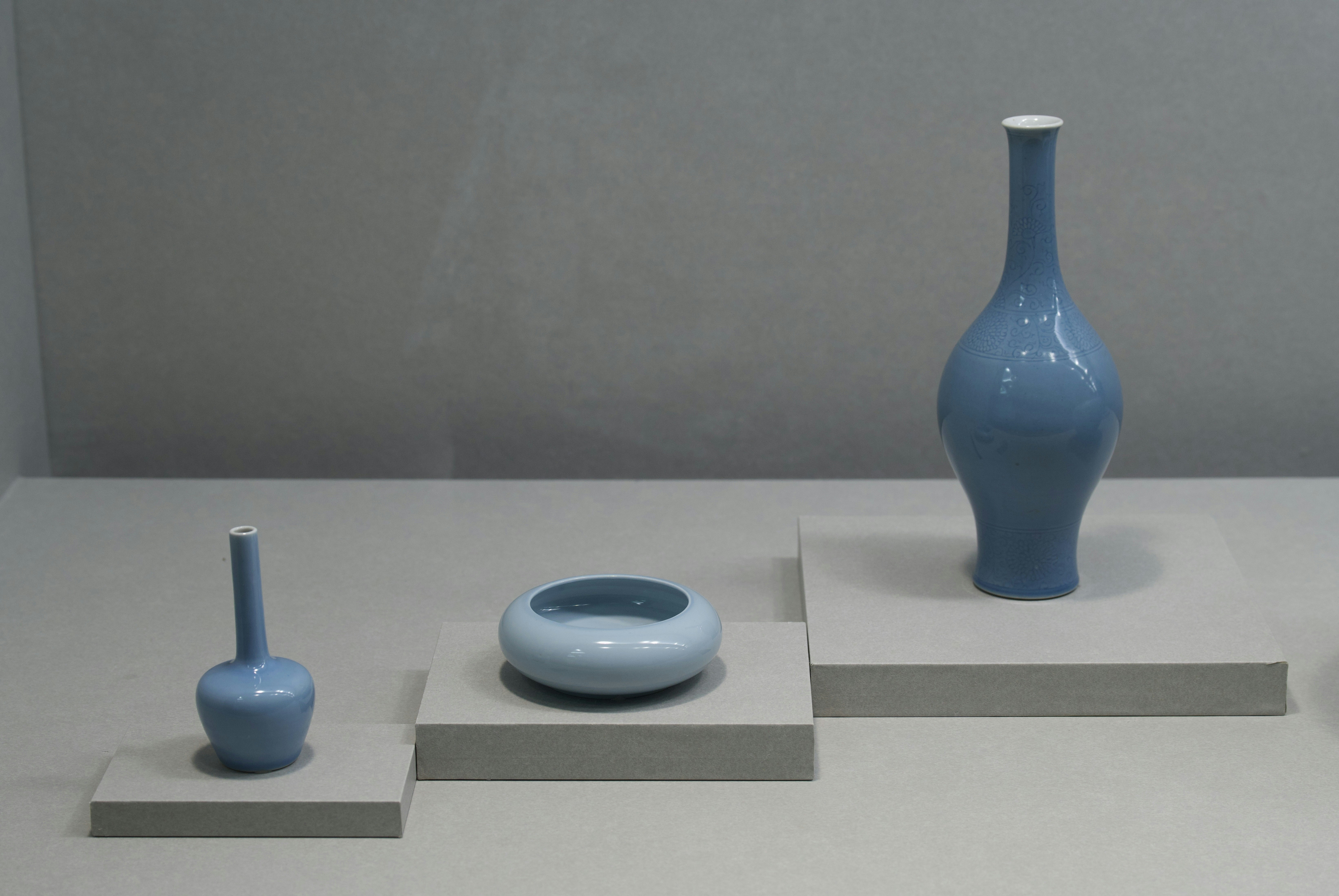 A group of blue vases sitting on top of a white table