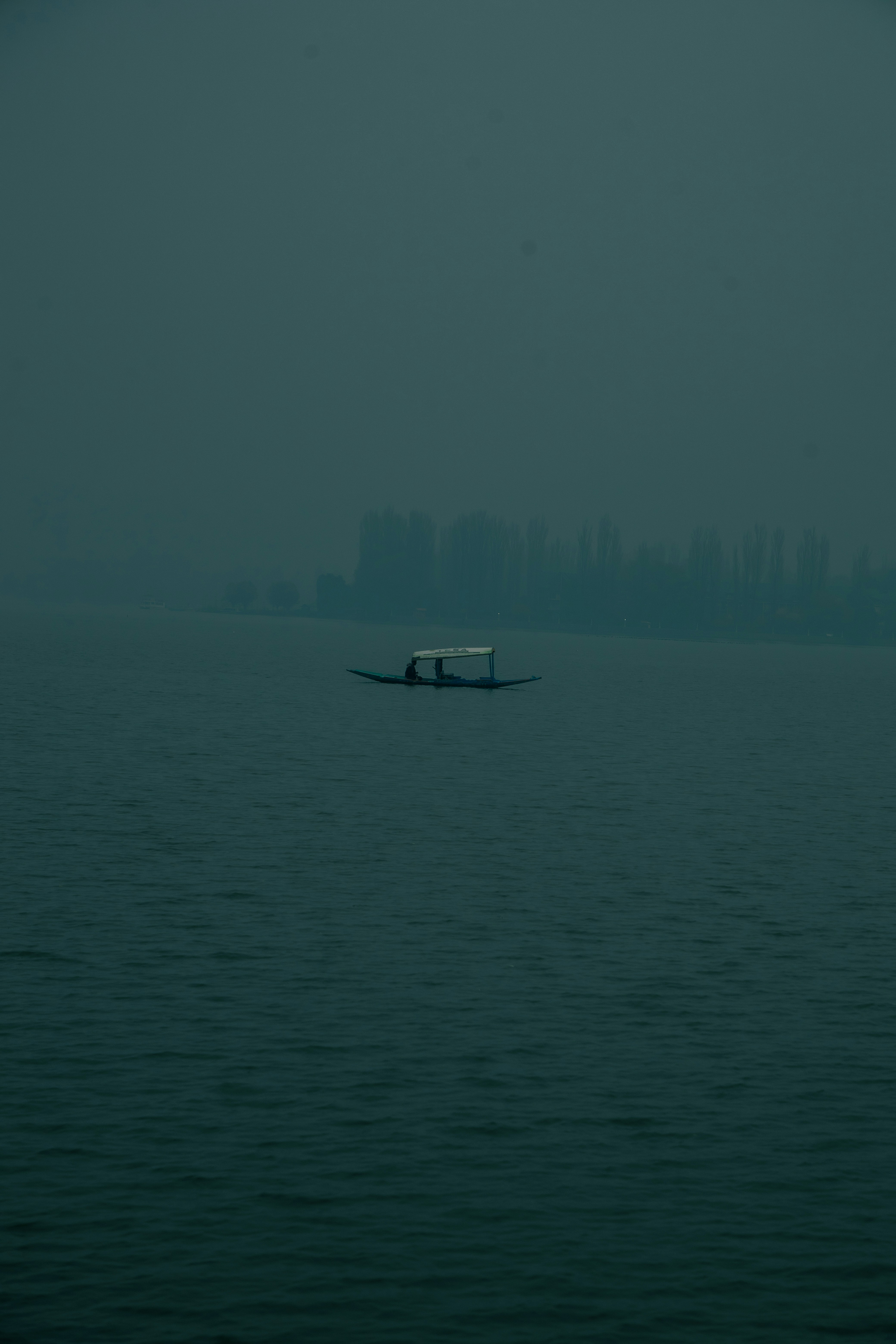 A boat in the middle of the ocean on a foggy day