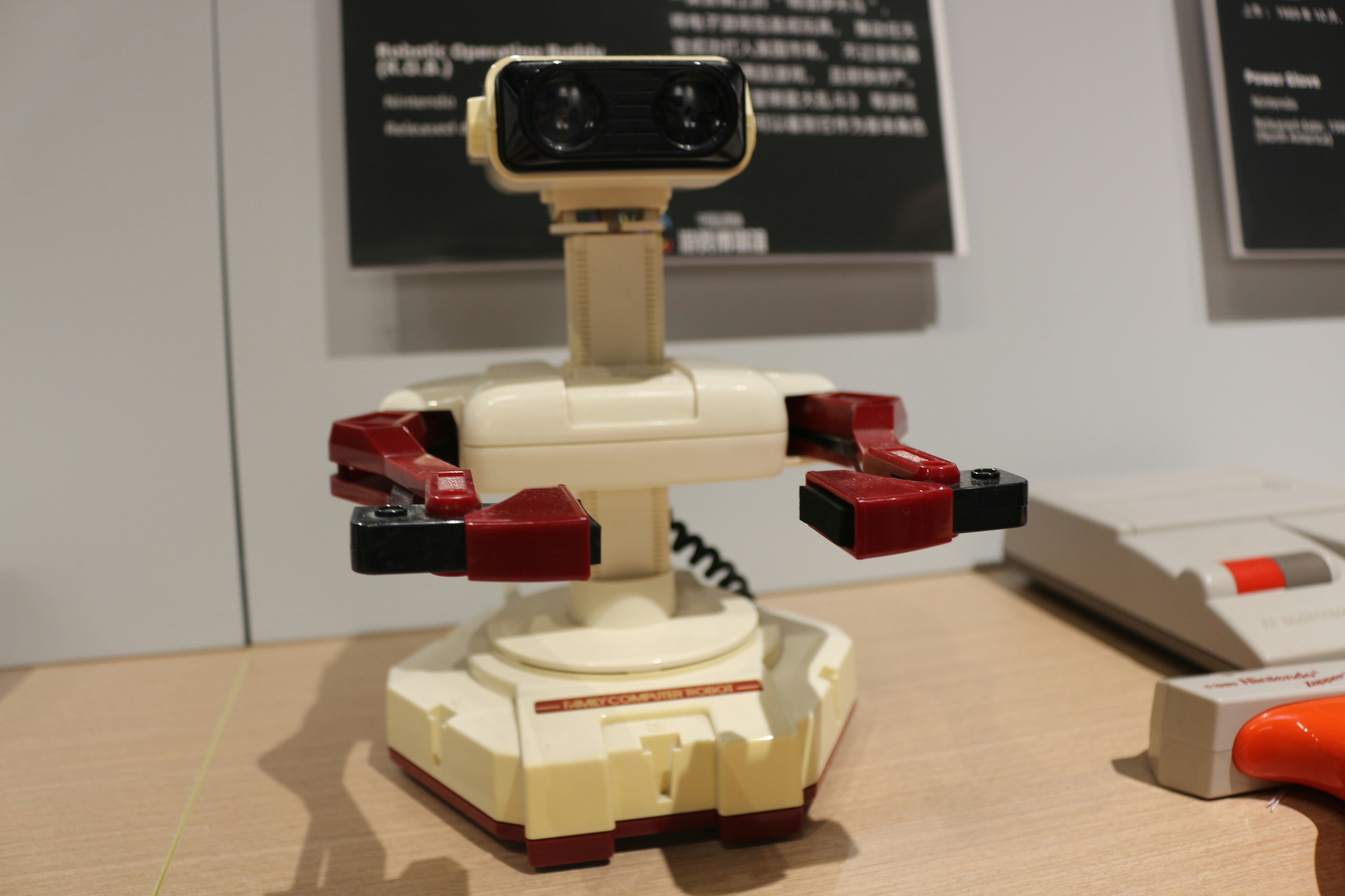 A table with a remote control and a robot on it