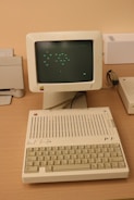 An old computer sitting on top of a wooden desk
