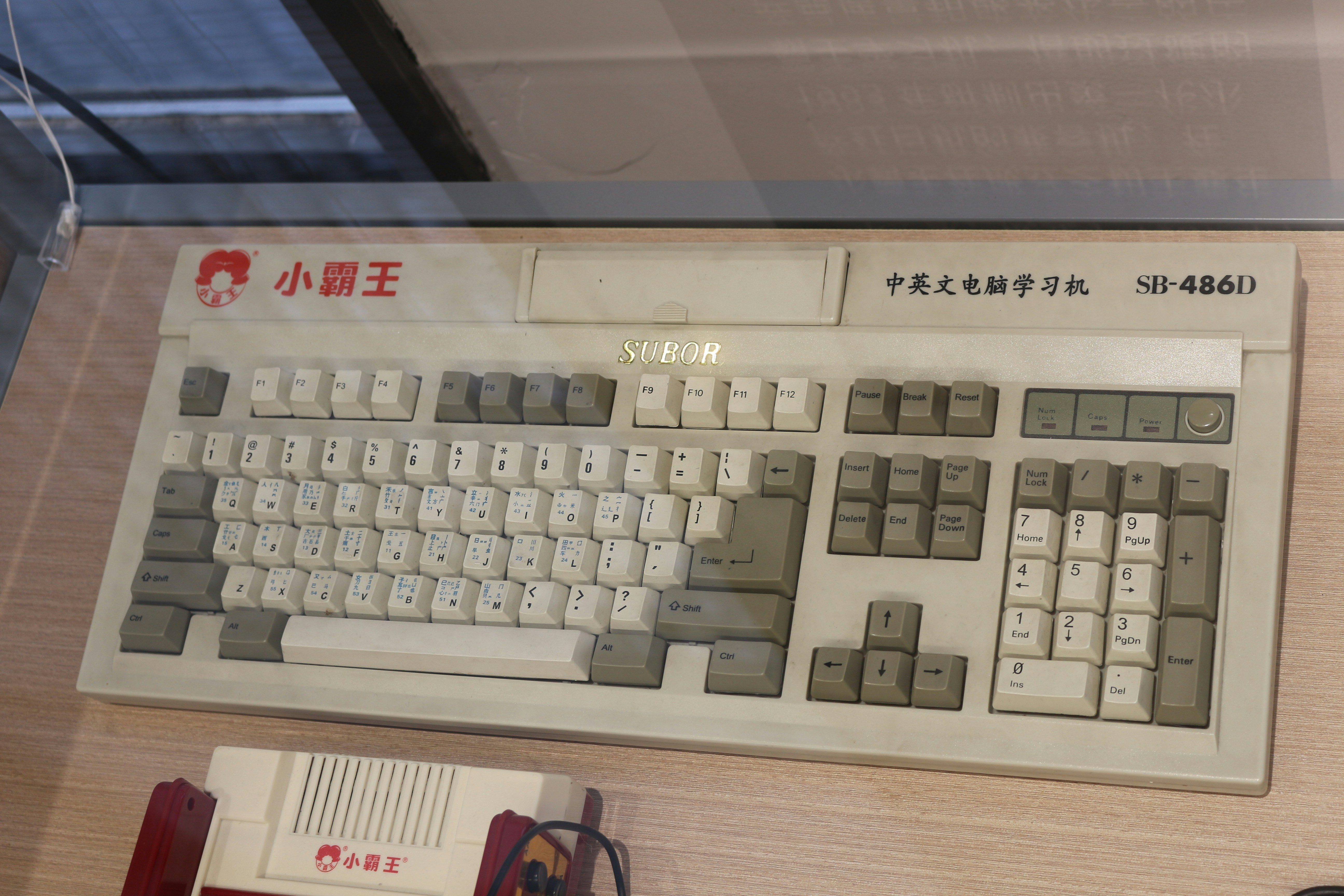 A computer keyboard sitting on top of a wooden desk