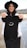 A woman holding up a t - shirt with a smiley face on it