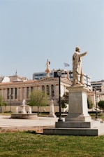 A statue of a man holding a flag in front of a building