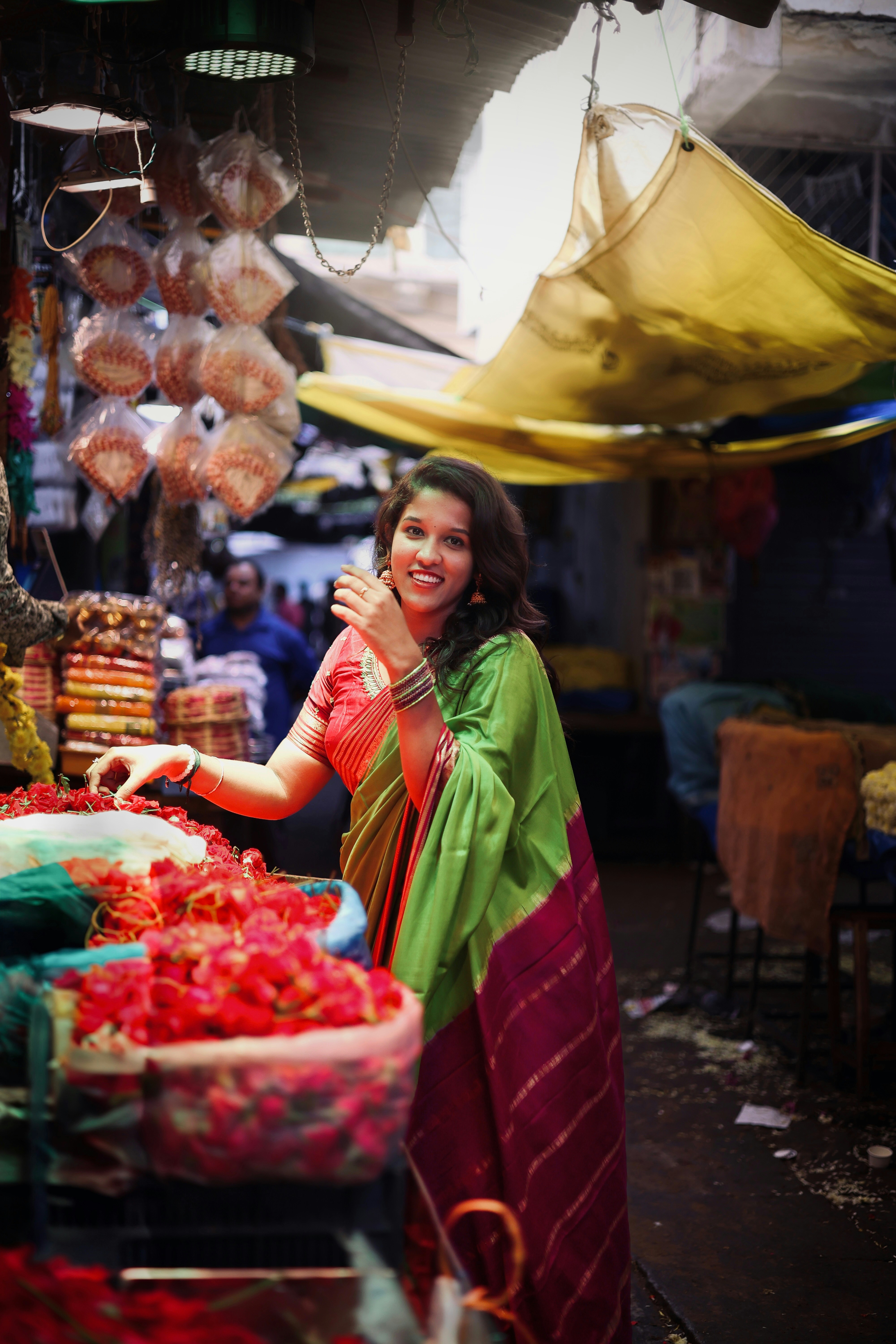 A woman standing in front of a fruit stand