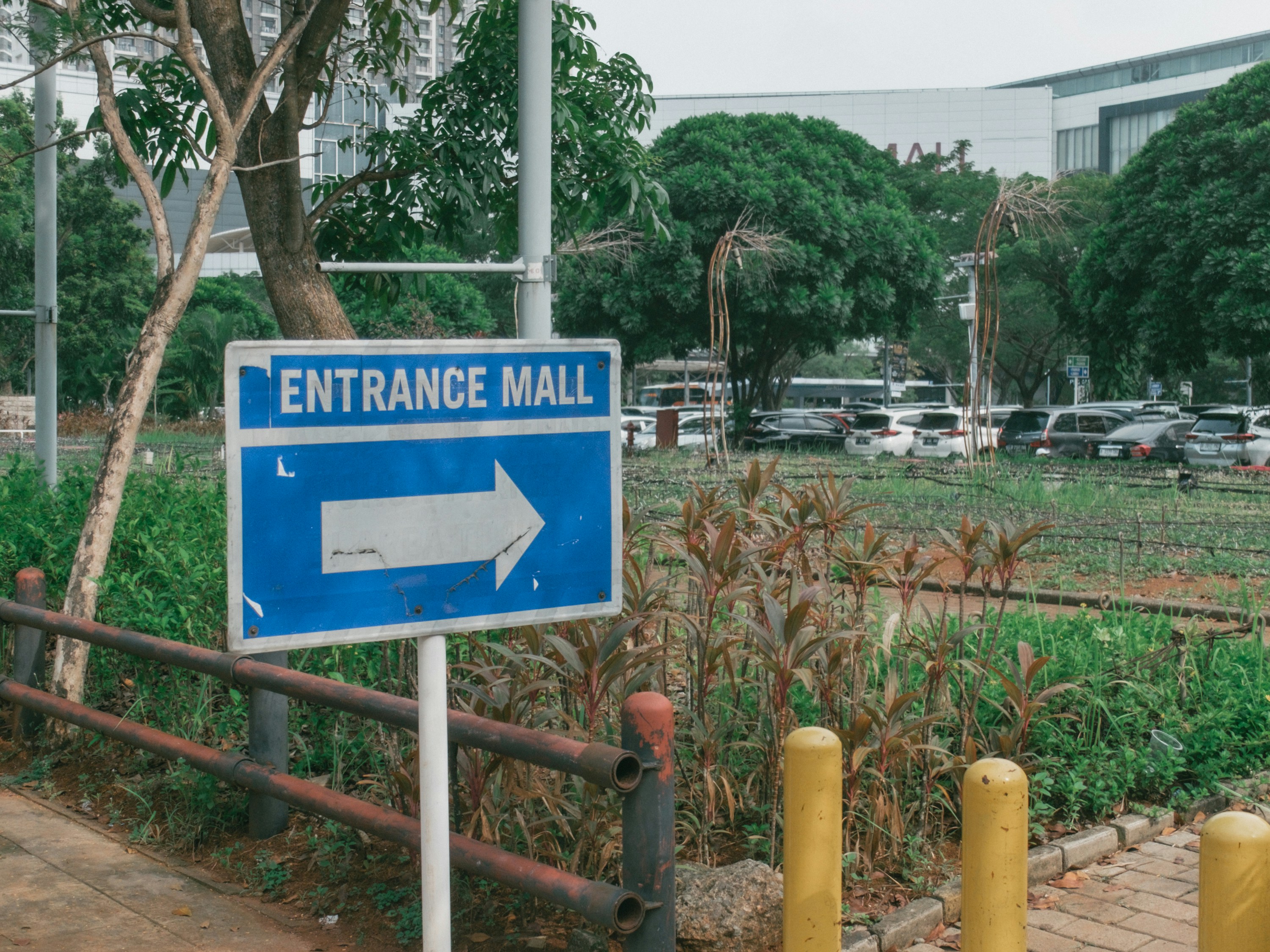 A blue sign pointing to the entrance of a mall