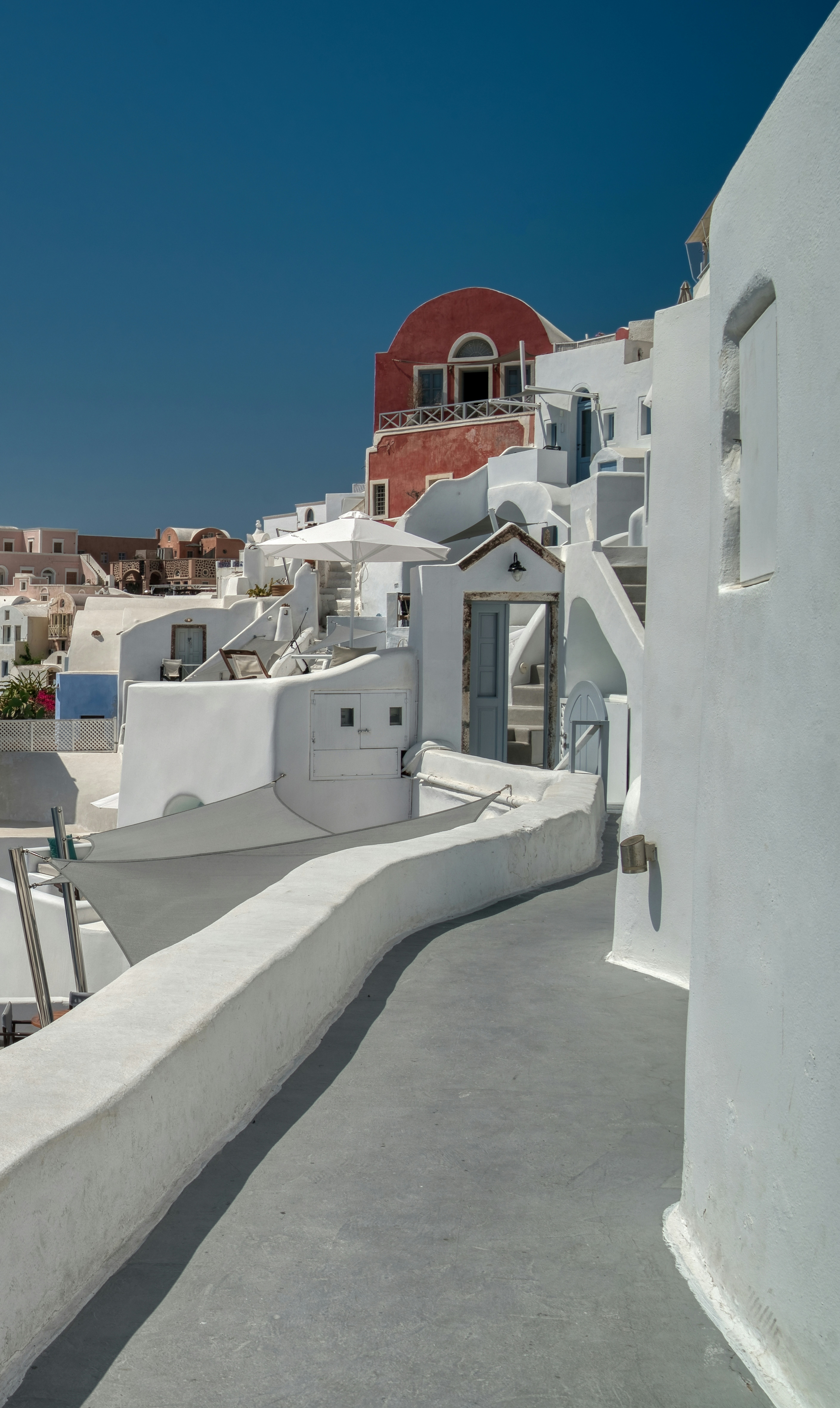 A view of a white building with a red dome in the background