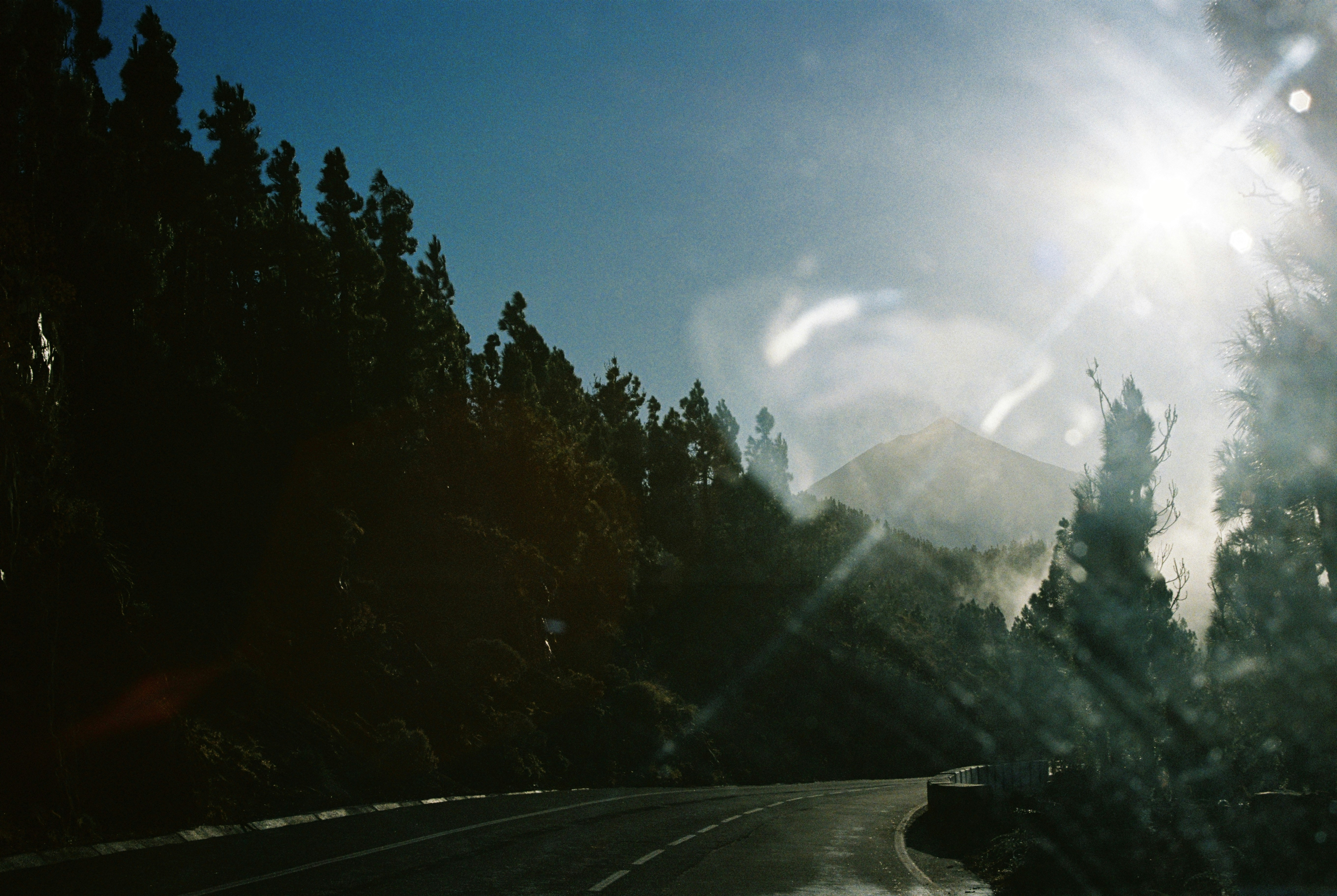 The sun shines brightly through the windshield of a car