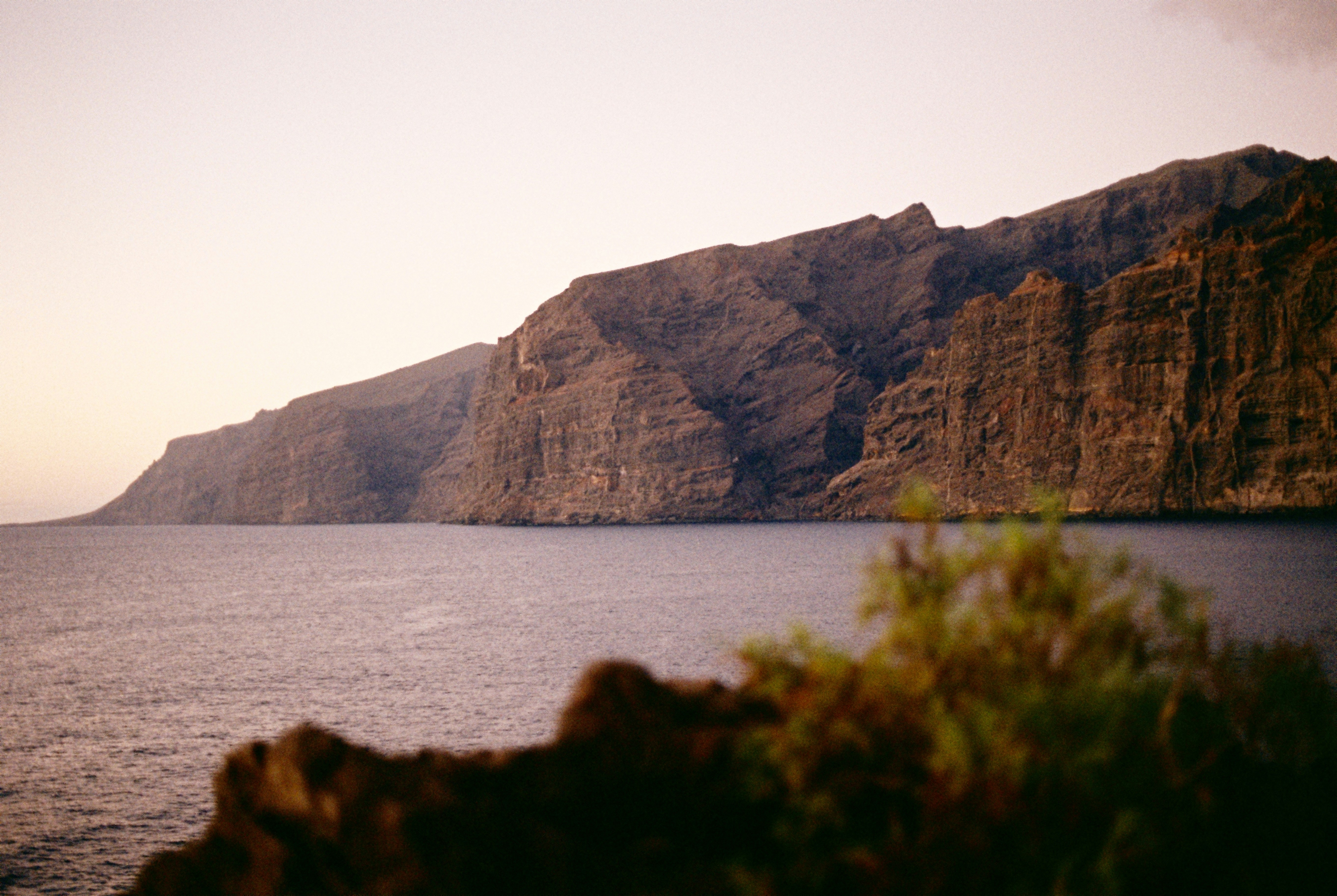 A body of water with a mountain in the background