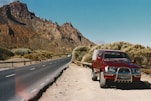 A red truck parked on the side of a road