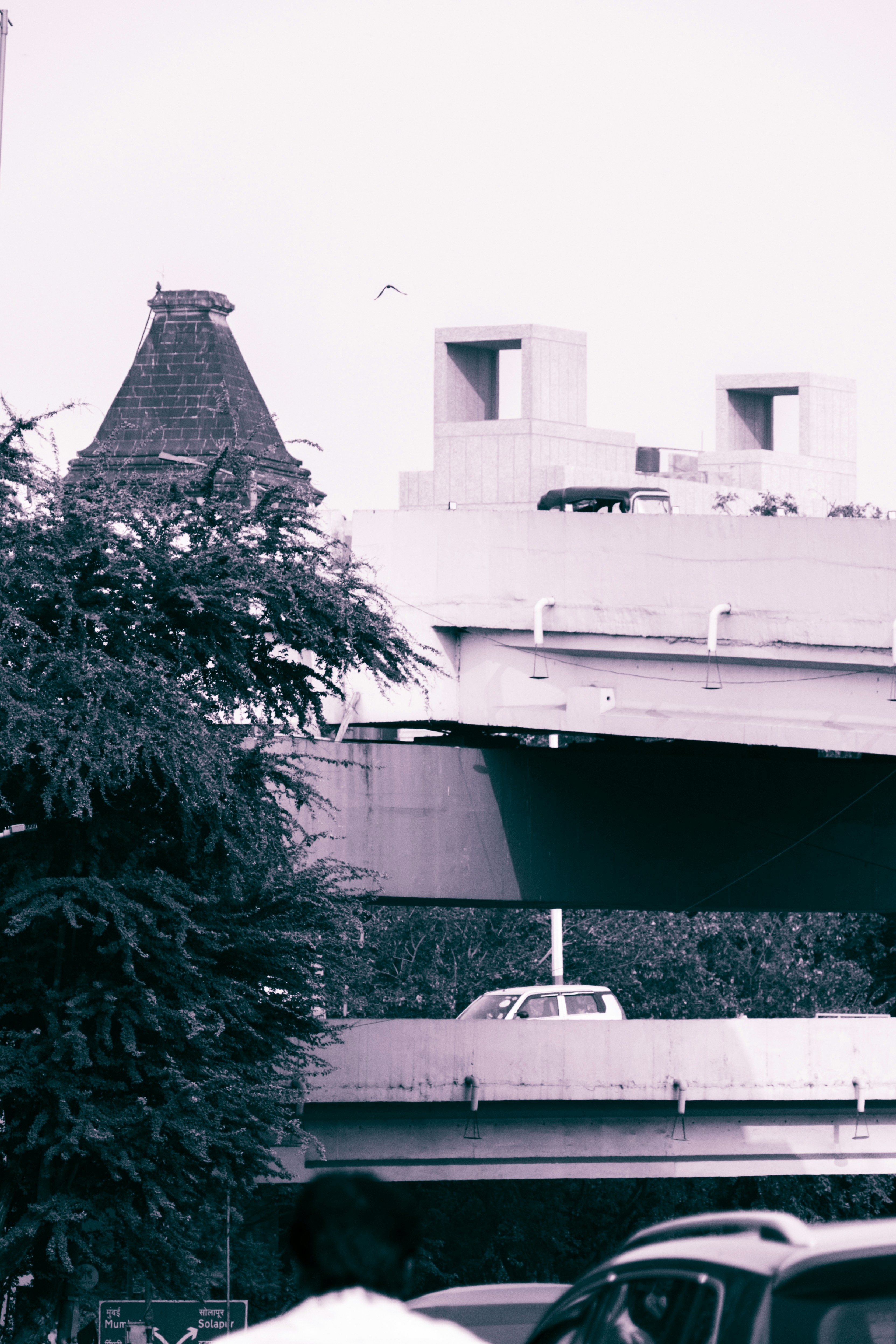 A black and white photo of cars and a bridge